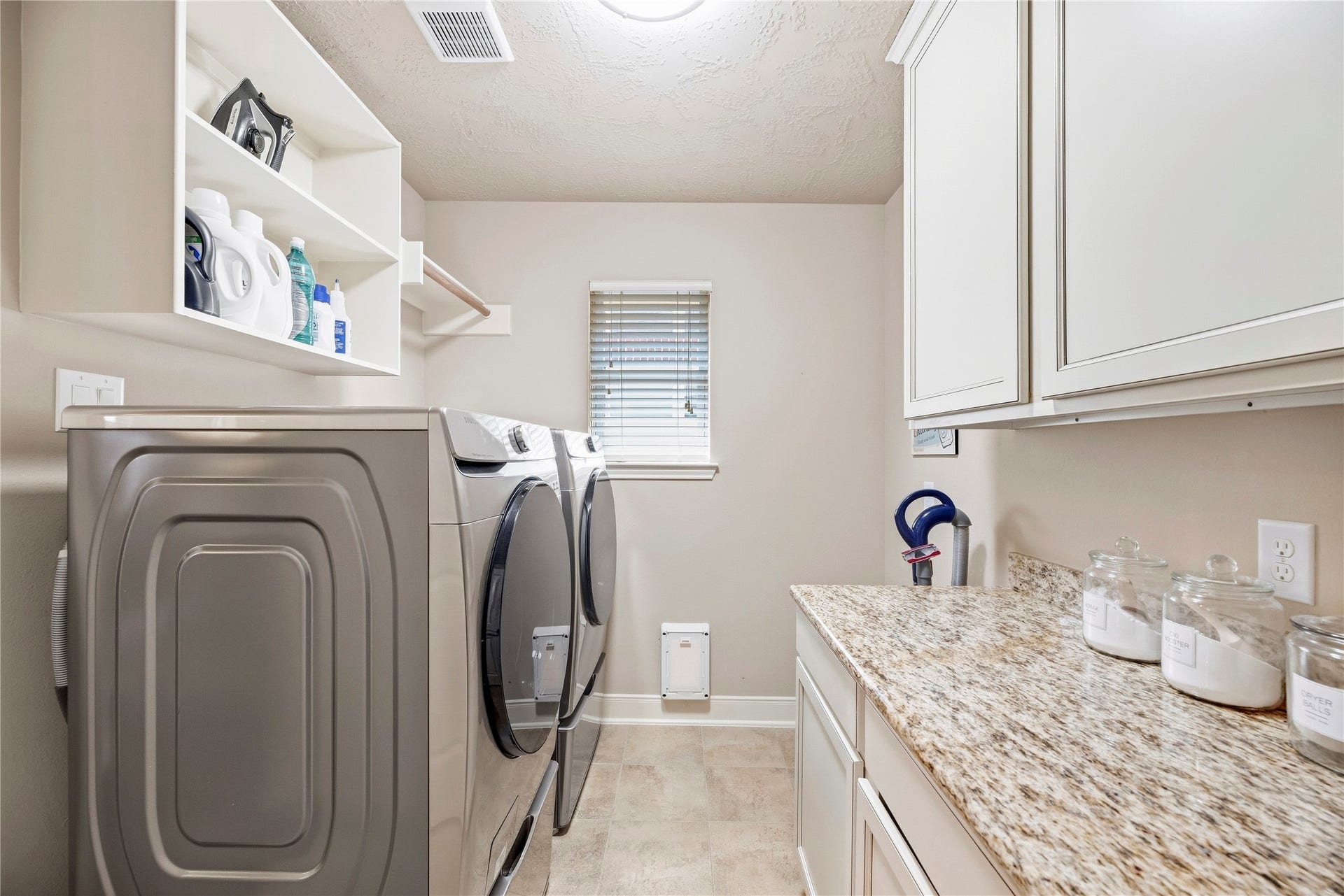 8623 Crescent Spur Drive, Richmond, TX 77406 A dedicated utility room with cabinetry and counter space makes laundry day simple and organized.