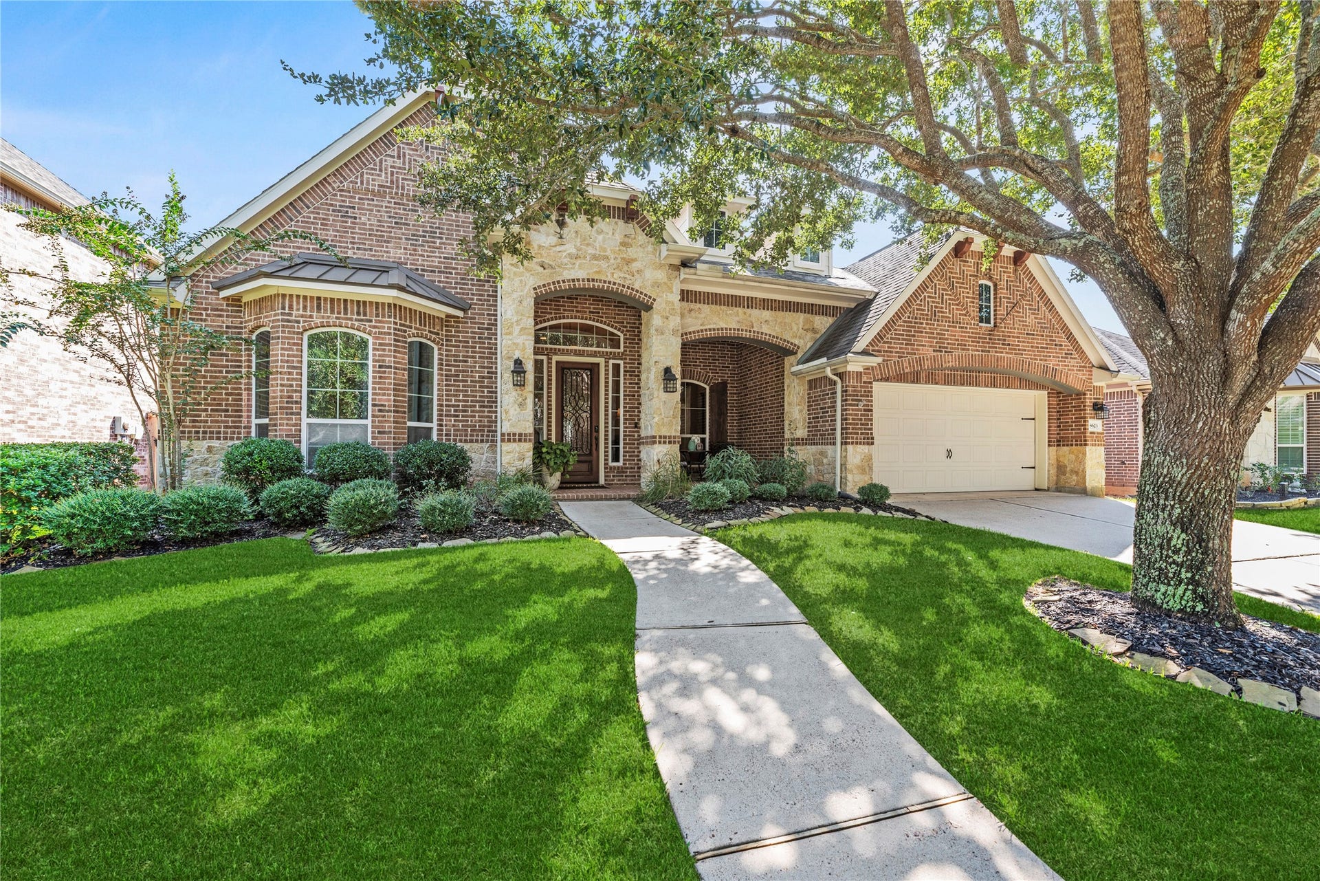 8623 Crescent Spur Drive, Richmond, TX 77406 A classic brick elevation framed by mature shade trees and a manicured lawn offers timeless curb appeal.