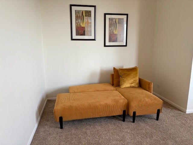 2016 Main Street, #PH 3, Houston, TX 77002 Cozy corner featuring a stylish mustard chaise lounge against a neutral wall, accented by modern artwork above, offering a perfect spot to relax.