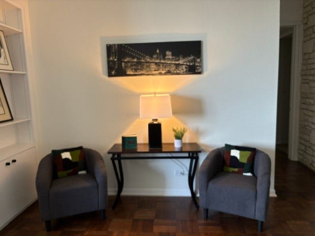 2016 Main Street, #PH 3, Houston, TX 77002 Cozy seating area with two stylish armchairs, a sleek table, and elegant decor, perfect for relaxing or entertaining.