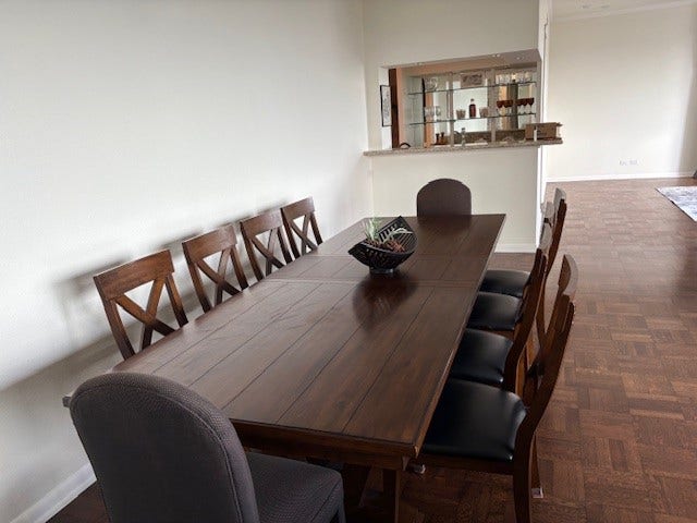 2016 Main Street, #PH 3, Houston, TX 77002 Elegant dining area featuring a long wooden table with stylish chairs, perfect for hosting gatherings. The open layout offers a seamless connection to adjacent spaces, enhancing the home's inviting atmosphere.