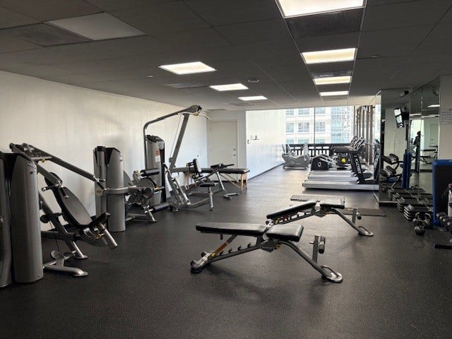 2016 Main Street, #PH 3, Houston, TX 77002 Spacious fitness center with modern exercise equipment, including weight machines, benches, and treadmills, all set in a bright, well-lit area.