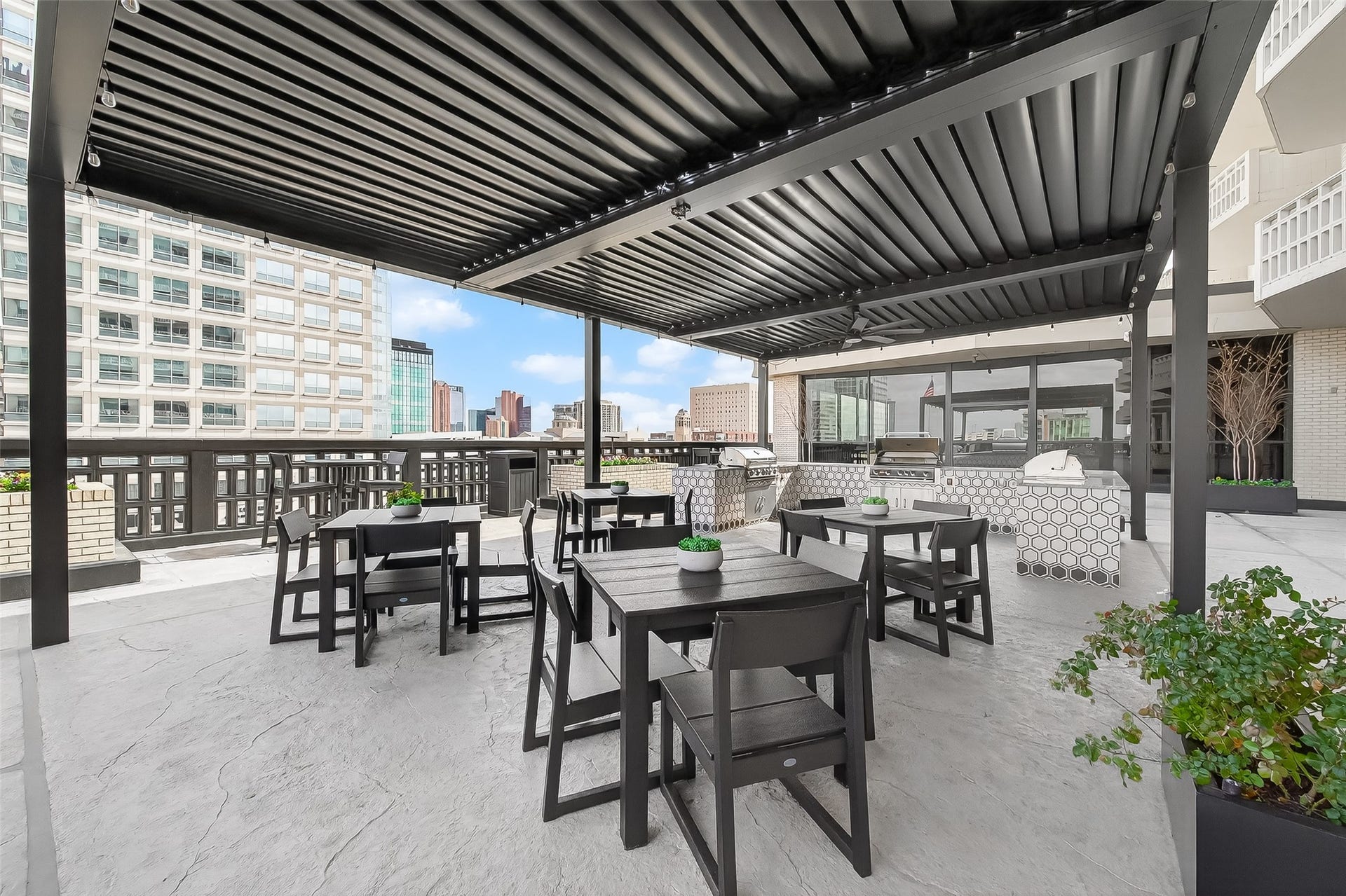 2016 Main Street, #PH 3, Houston, TX 77002 Stylish outdoor terrace featuring a covered seating area with modern furniture and a built-in grill, perfect for entertaining with stunning city views.