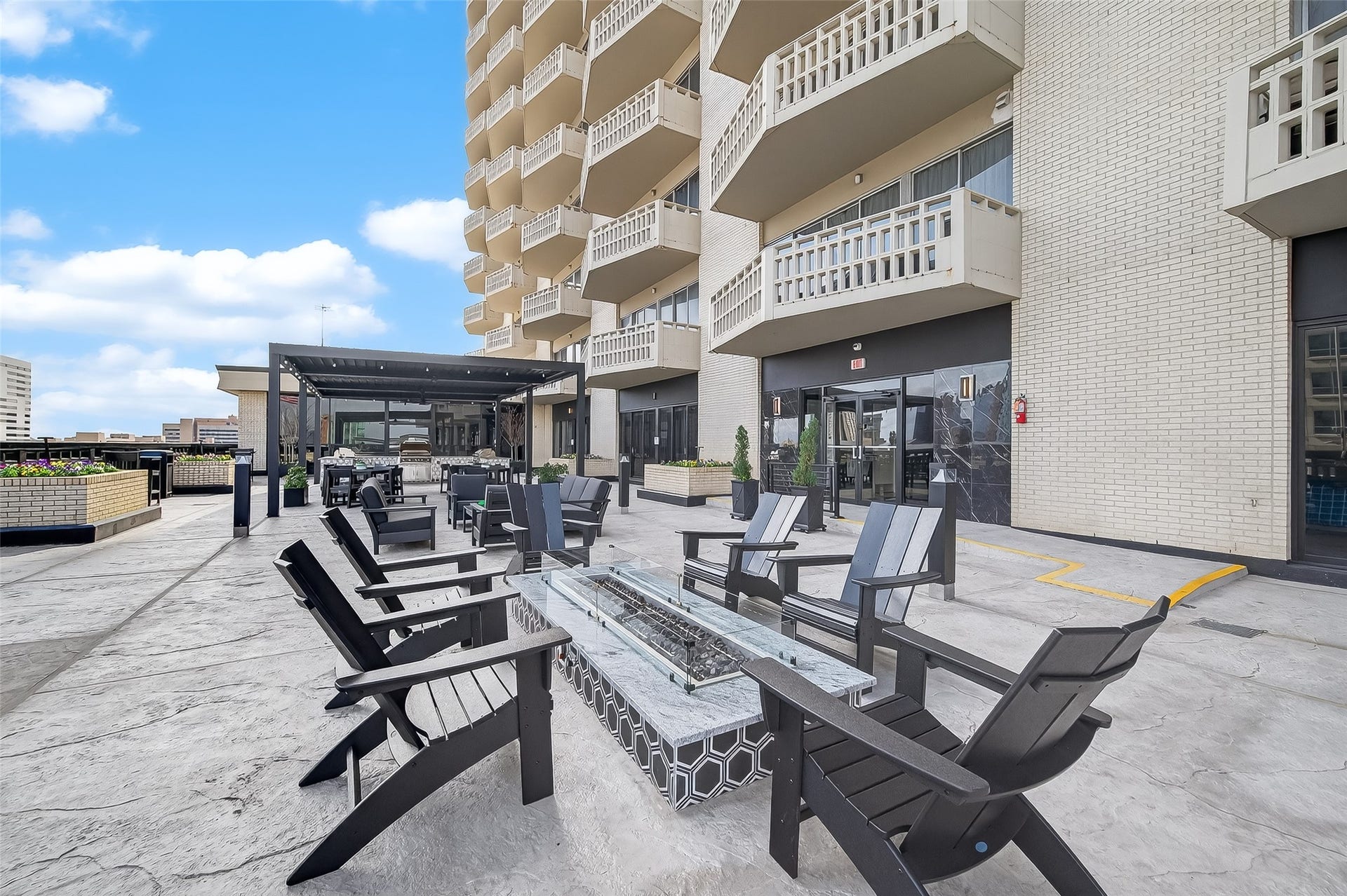 2016 Main Street, #PH 3, Houston, TX 77002 Spacious outdoor patio with comfortable seating and a modern fire pit, perfect for entertaining and enjoying city views.