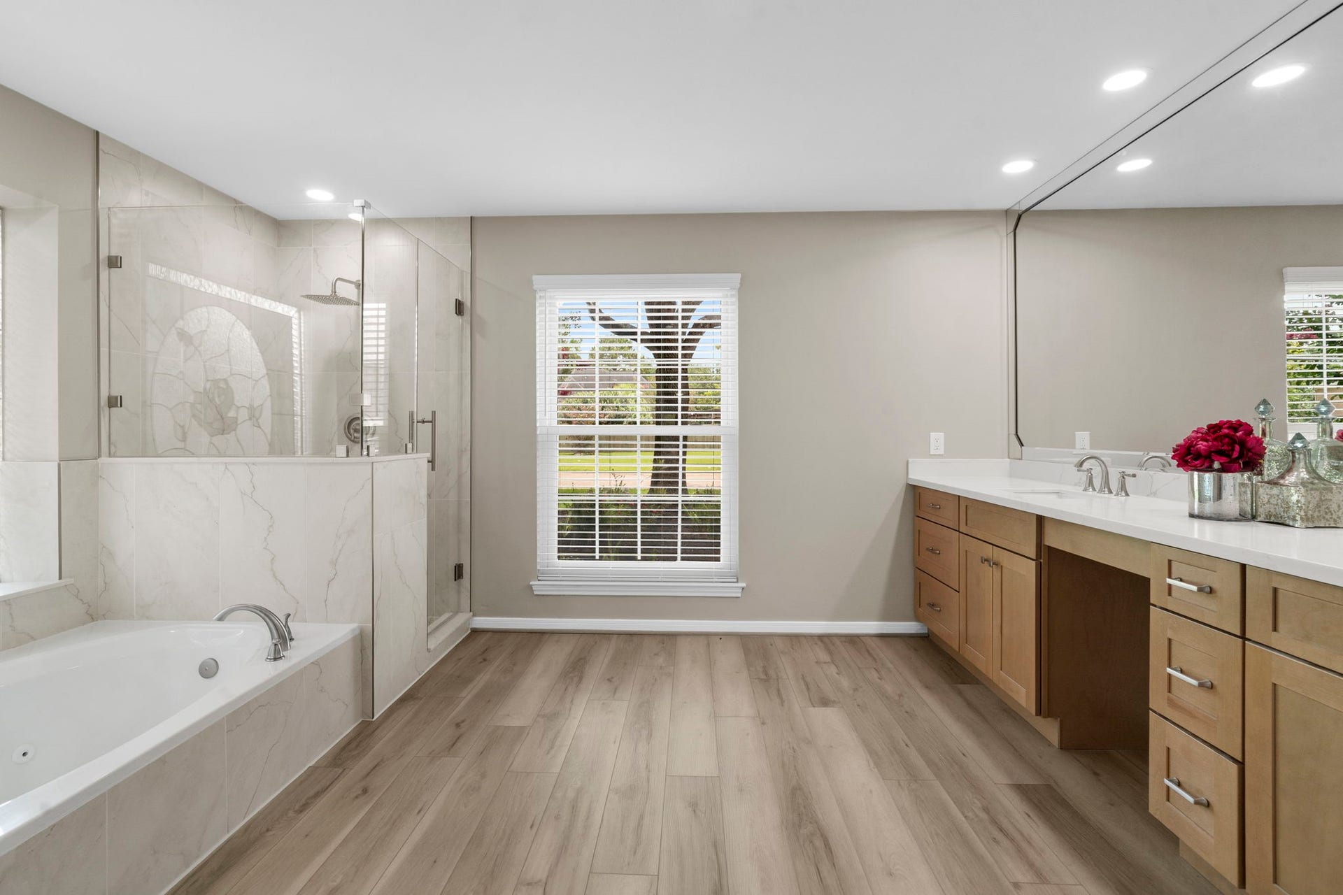 The spa-inspired primary bath continues with a soaking tub, oversized frameless glass shower & beautiful designer tile extending throughout the shower and tub surround.