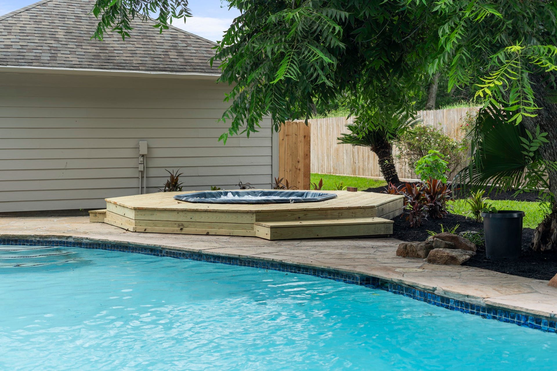 A separate hot tub with a newly built surround creates its own dedicated space just steps from the pool.