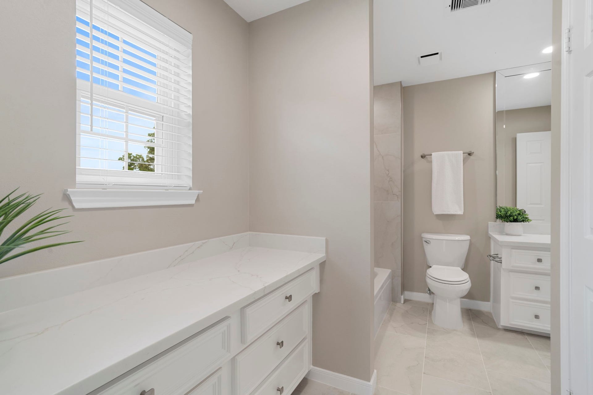 An extended vanity area adds valuable counter space & storage, while the updated finishes create a fresh, polished look throughout this dual-access bath.