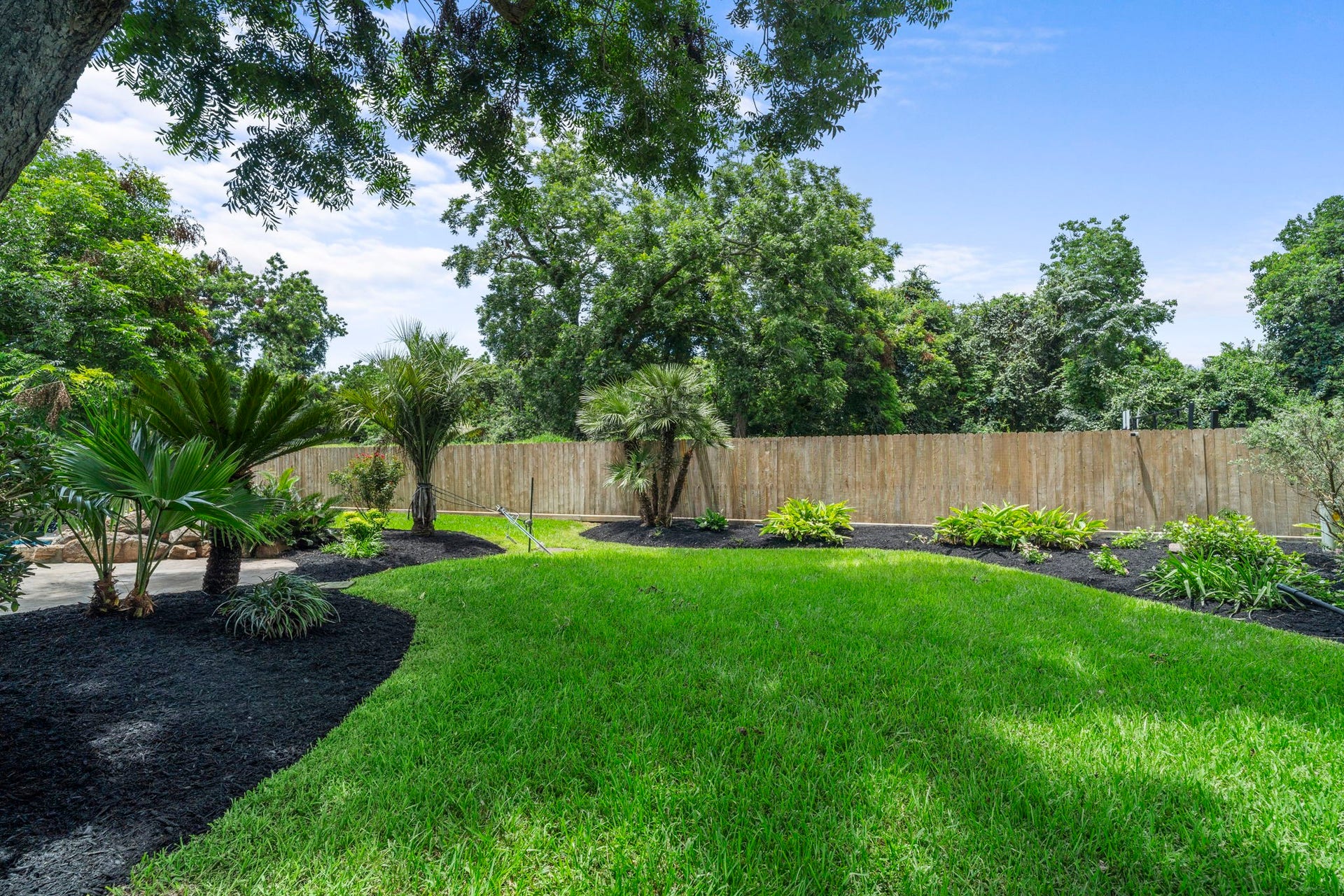 The oversized lot continues with an expansive lawn beyond the pool area, offering plenty of usable yard space while established landscaping adds a polished finish.