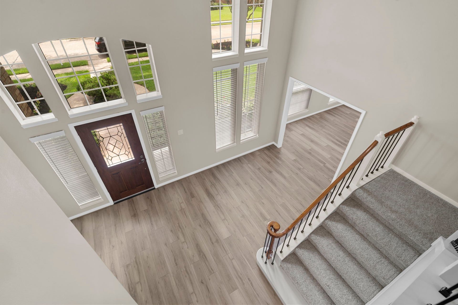 The dramatic two-story foyer is filled with natural light from stacked windows surrounding the entry.
