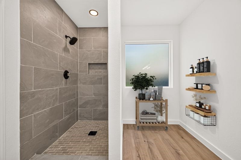 Elegant bathroom featuring a spacious walk-in shower with modern tile work, complemented by stylish wall shelves and a serene view.
