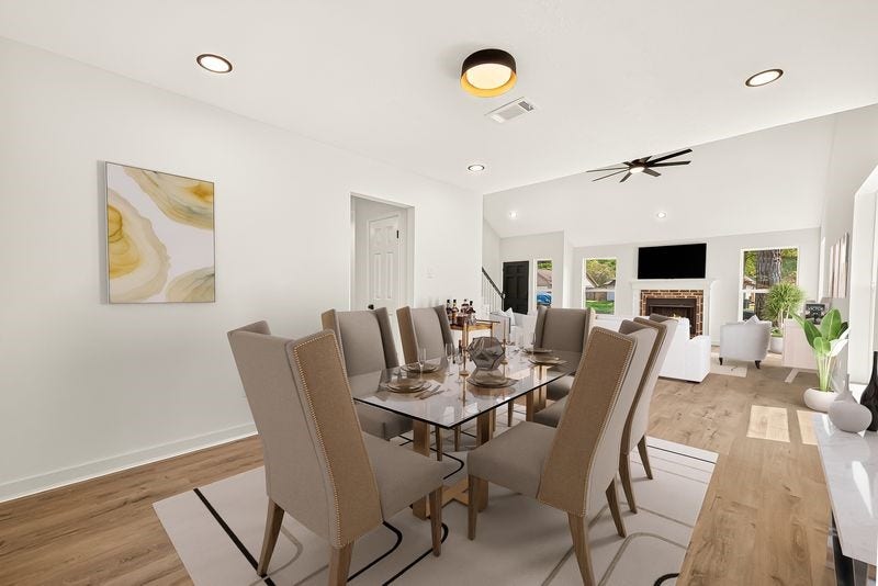 Elegant open-concept dining area with modern fixtures, seamlessly connected to a bright living space featuring a cozy fireplace and abundant natural light.