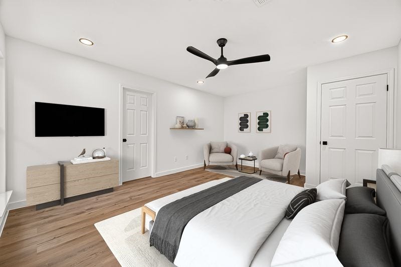 Spacious and modern bedroom featuring sleek hardwood floors, a stylish ceiling fan, and ample natural light.
