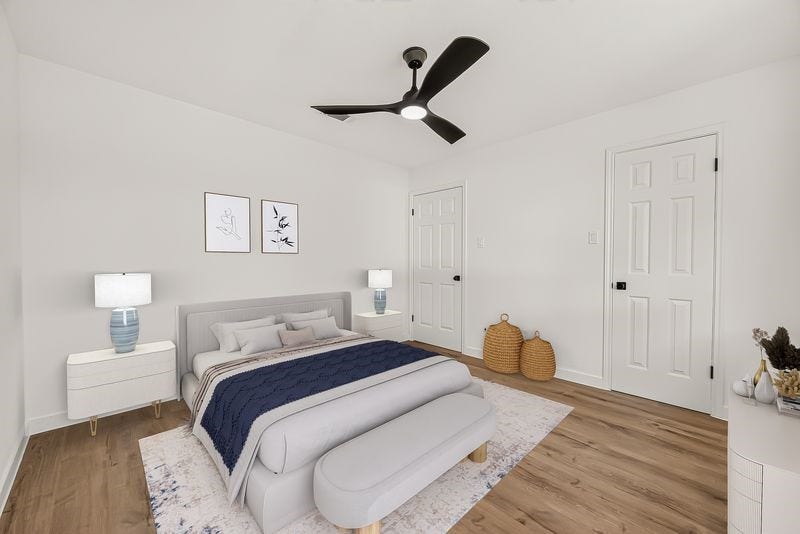 Bright and inviting bedroom featuring a modern ceiling fan, stylish decor, and sleek wood flooring.