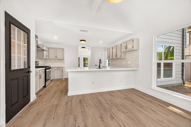 Bright and airy kitchen with modern cabinetry, sleek countertops, and a spacious island, complemented by warm wood flooring and ample natural light.