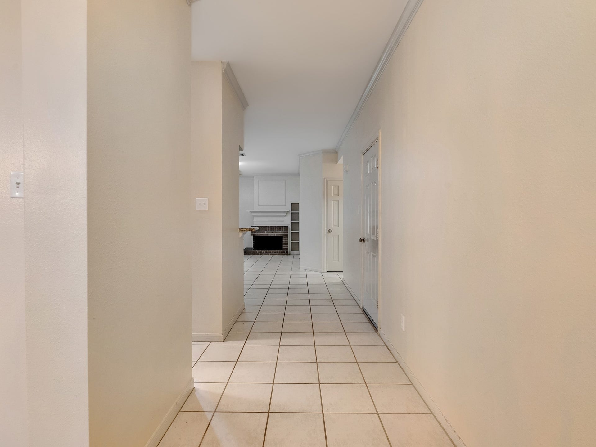 View from entry leading to the family room with the dining room and kitchen to the left and garage access to the right