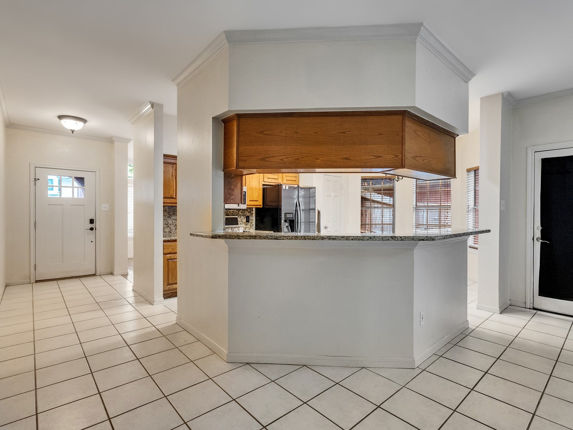 View of entry and kitchen equipped with a breakfast bar
