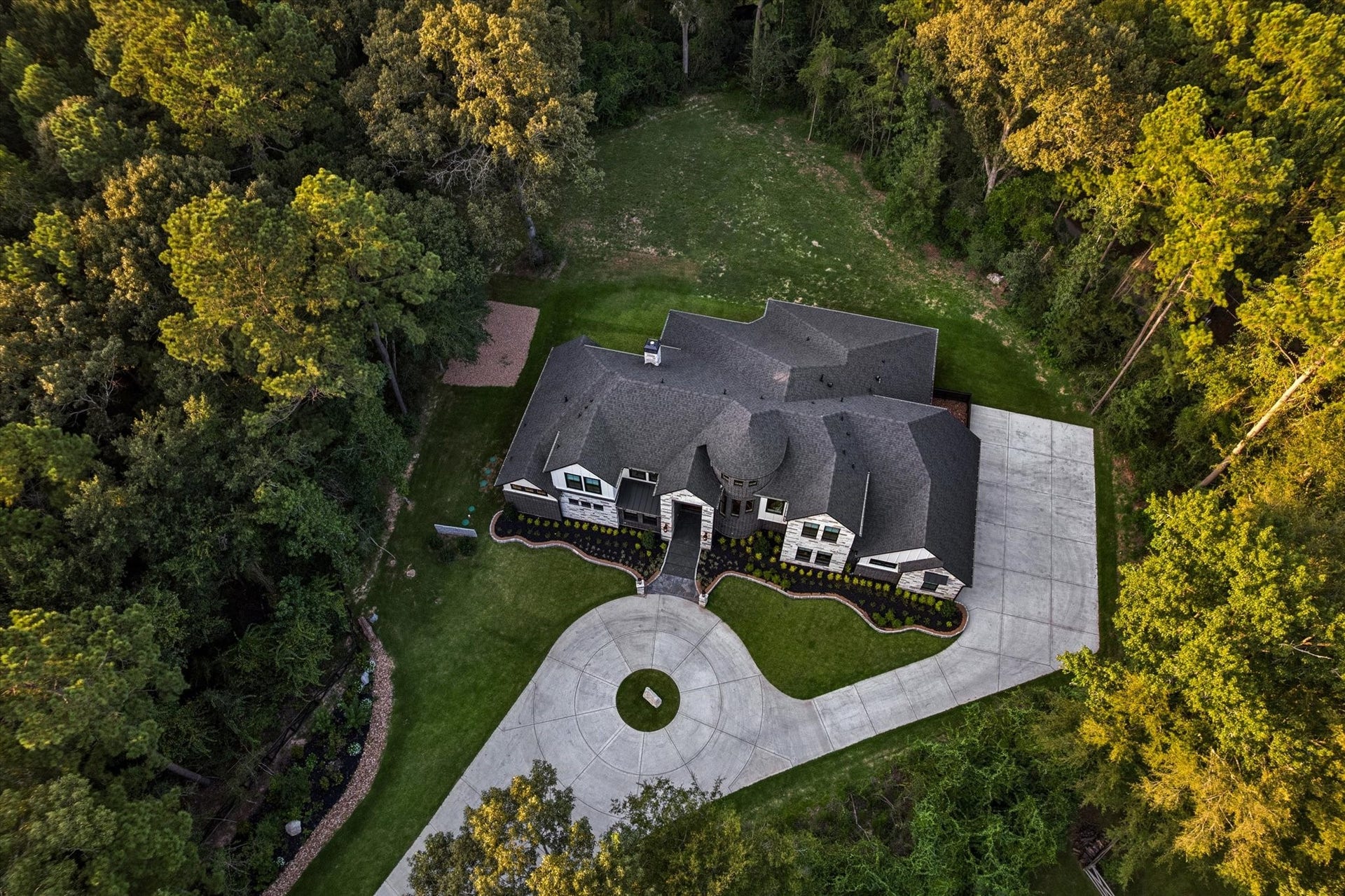 This elevated perspective beautifully showcases the estate's thoughtfully designed placement on the property. Positioned well back from the road and embraced by mature trees, the home offers a rare combination of privacy, serenity, and elegance. The expansive homesite creates a true estate-like presence while providing generous outdoor space for entertaining, recreation, or simply enjoying the peaceful beauty of the surrounding landscape.