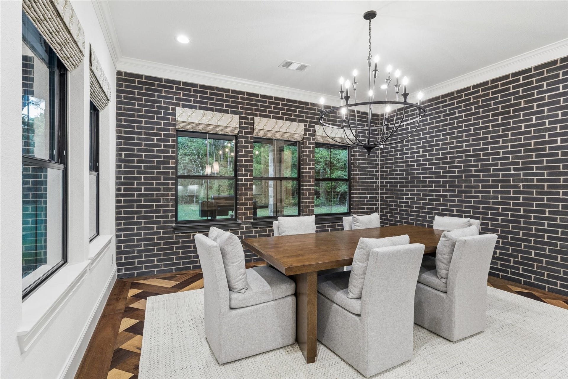 Every detail within the dining room has been thoughtfully selected to create a refined yet comfortable atmosphere. The combination of dramatic architectural textures, elegant finishes, and designer lighting provides the perfect backdrop for everything from formal entertaining to everyday family meals. Large windows frame peaceful outdoor views while filling the room with beautiful natural light, making this space feel both sophisticated and welcoming throughout the day.