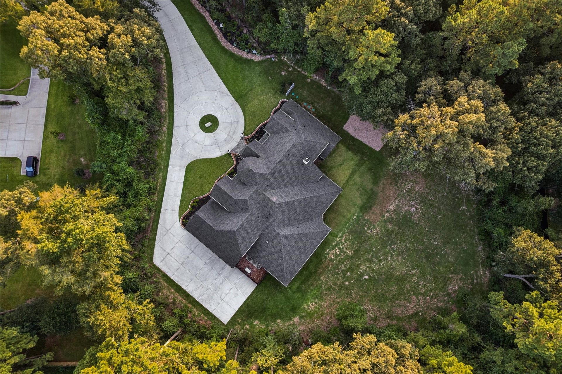 From above, the full beauty of this custom residence comes into focus. Every angle highlights the exceptional craftsmanship, architectural symmetry, and careful planning that define this remarkable property. The expansive rooflines, circular drive, and beautifully integrated homesite create an unforgettable first impression. With approximately 5,550 square feet of thoughtfully designed living space, this estate offers the perfect balance of grandeur, comfort, and everyday functionality.