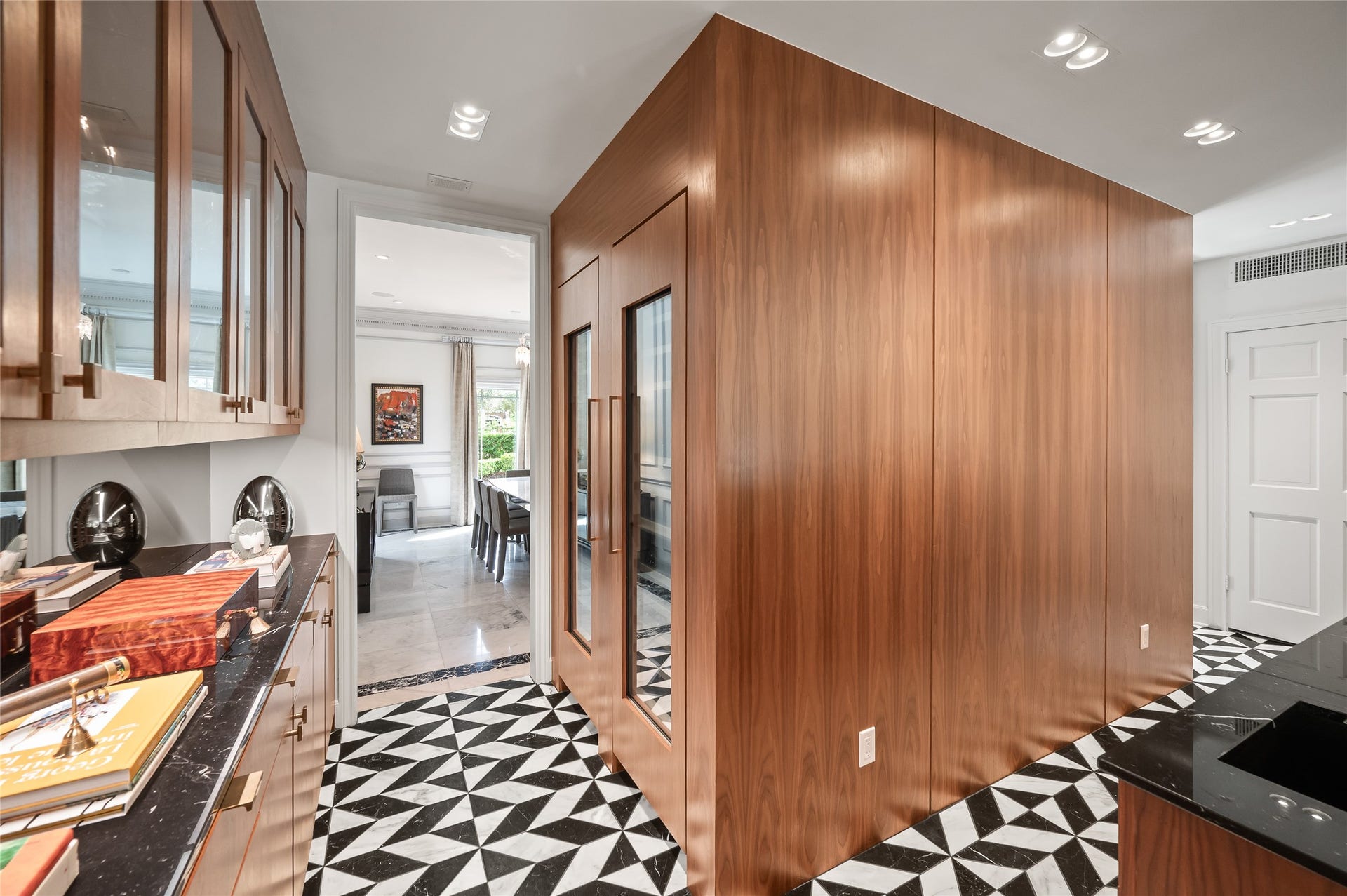 [Full Bar]
The full bar also serves as a butler's pantry with walnut upper and lower cabinets and extensive countertop storage. Walnut cabinet at center holds a Thermador dual-temperature wine chiller. Note custom-designed black and white marble tile floor and Nero Marquina countertops.