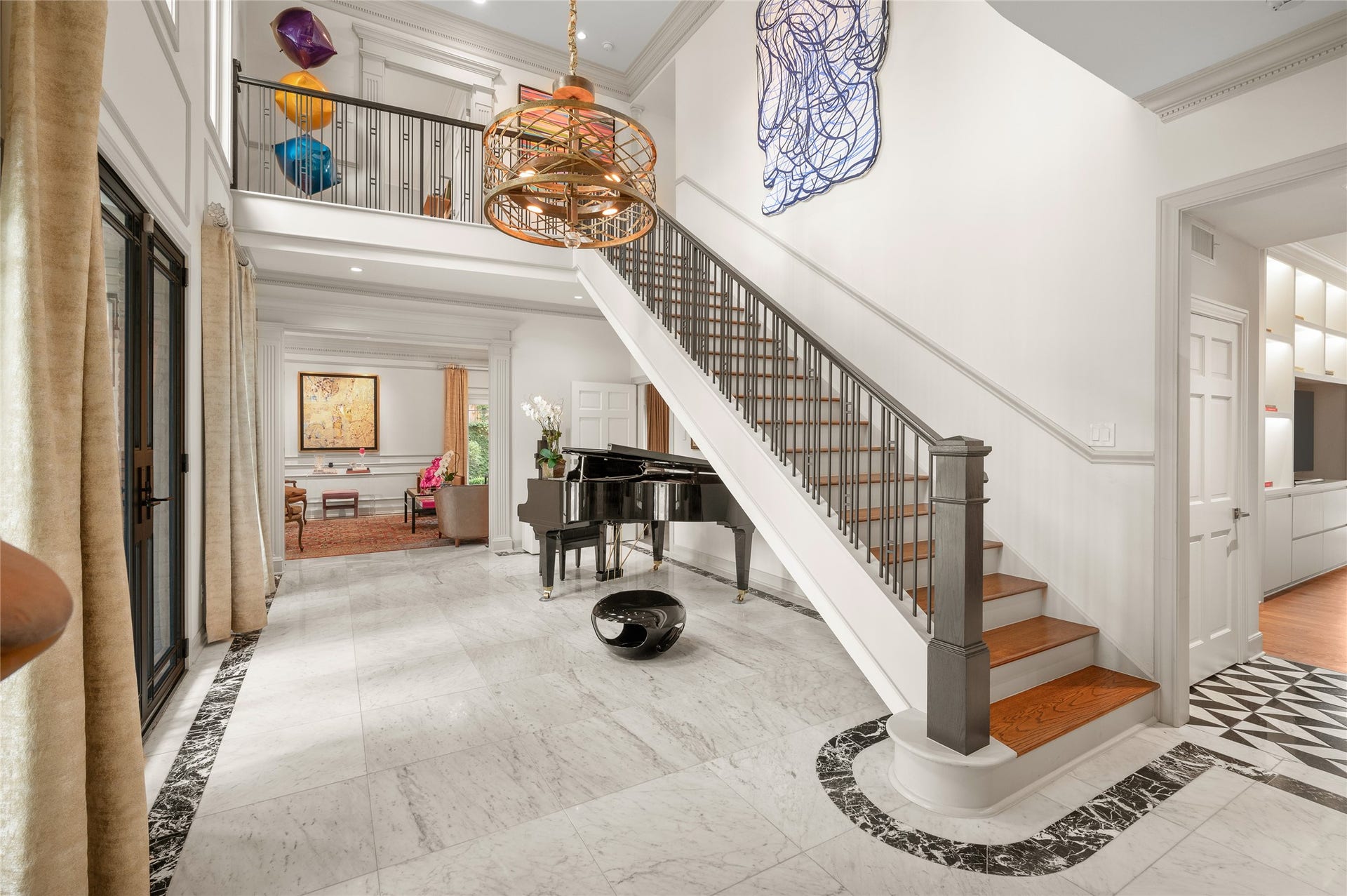[Foyer]
Exceptional, hand-selected marble tiles distinguish the foyer. Glass front door and full-length windows provide abundant natural light. Living room is shown through cased opening.