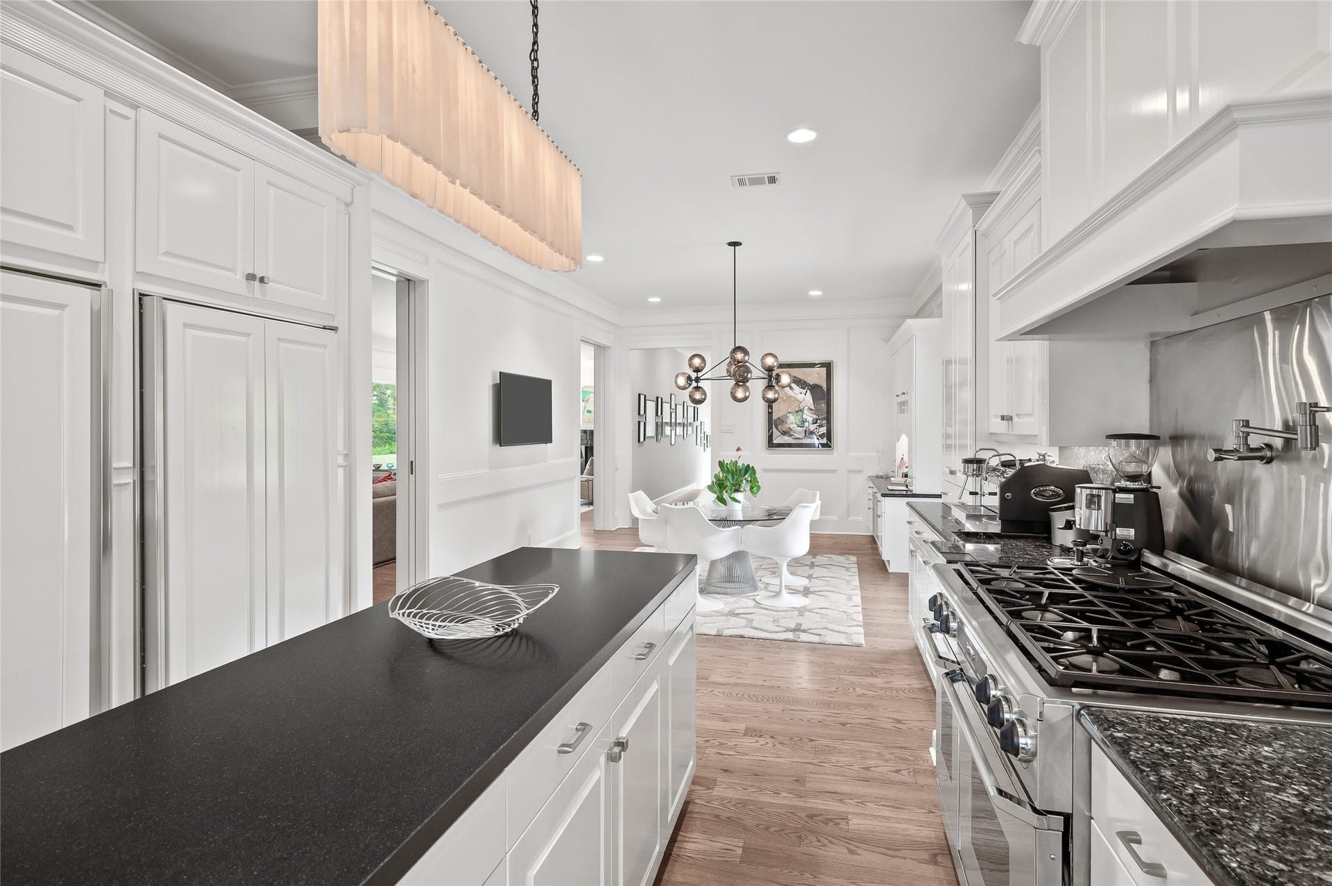 [Gathering Kitchen]
A reverse view of the kitchen travels across the island into the breakfast area. Note cabinet-front SubZero refrigerator and freezer (left).