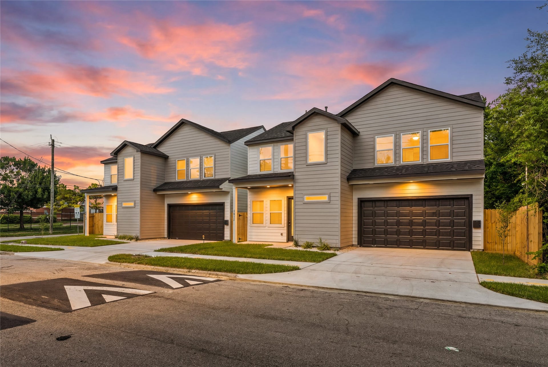 4702 & 1912 Schweikhardt Street, Houston, TX 77020 Golden hour elegance. The exterior lighting accents the modern geometry and rich textures of the home, showcasing a stunning street-side view that feels both secure and inviting.