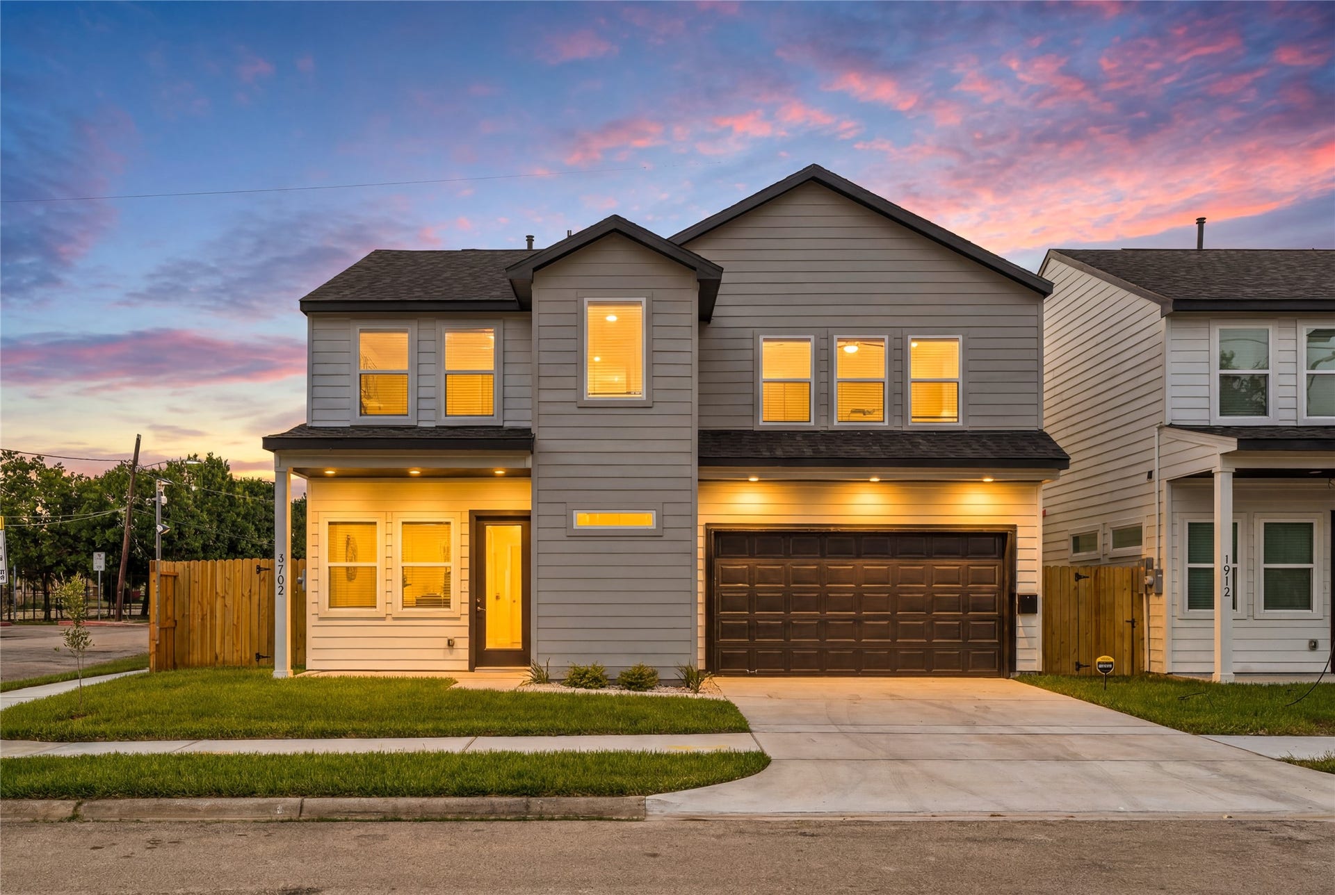 4702 & 1912 Schweikhardt Street, Houston, TX 77020 Stunning evening curb appeal dramatic exterior uplighting beautifully showcases the sharp architectural lines against a vibrant Texas sunset.