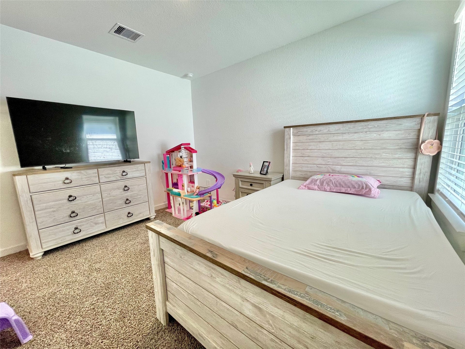 31722 Farlam Farms Trail, Fulshear, TX 77441 A bright and spacious secondary bedroom, beautifully styled as a charming kid's room with ample space for a full bedroom set.