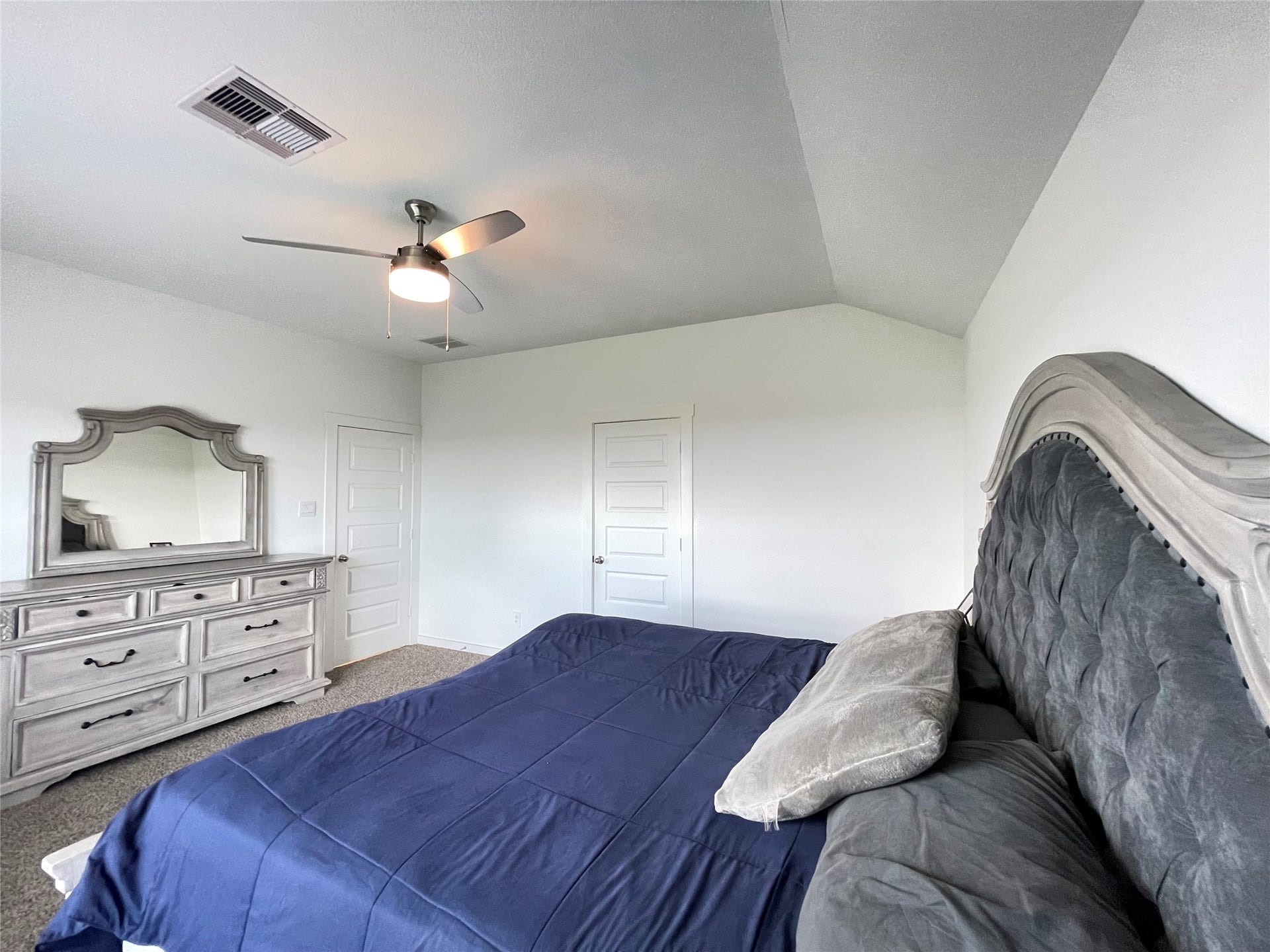 31722 Farlam Farms Trail, Fulshear, TX 77441 Another perspective of the expansive primary bedroom showcases its soaring ceilings and ample space for king-sized furniture.