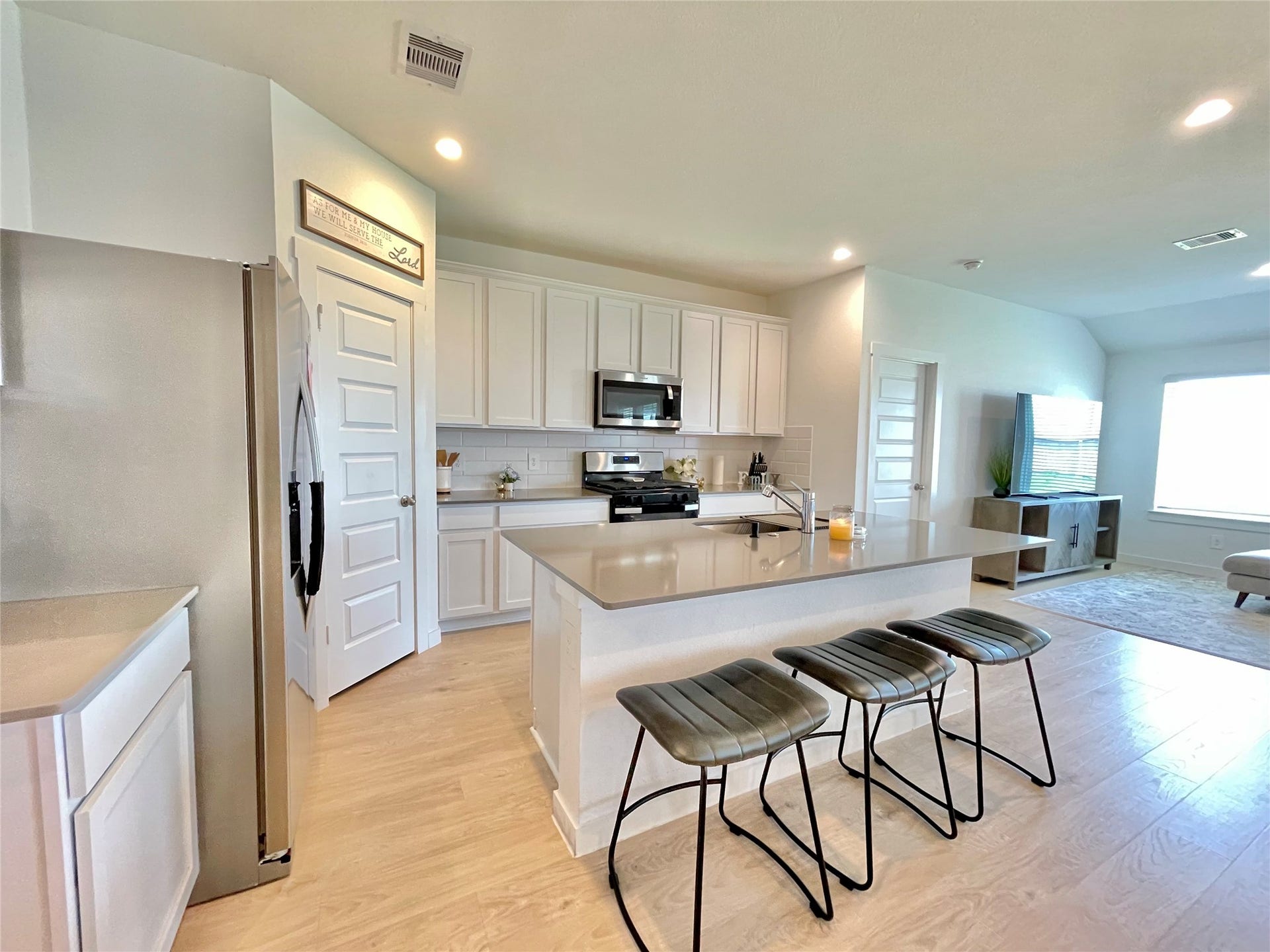 31722 Farlam Farms Trail, Fulshear, TX 77441 A chefs dream! The gourmet kitchen boasts pristine white cabinetry, high-end stainless steel appliances, and a massive central island.