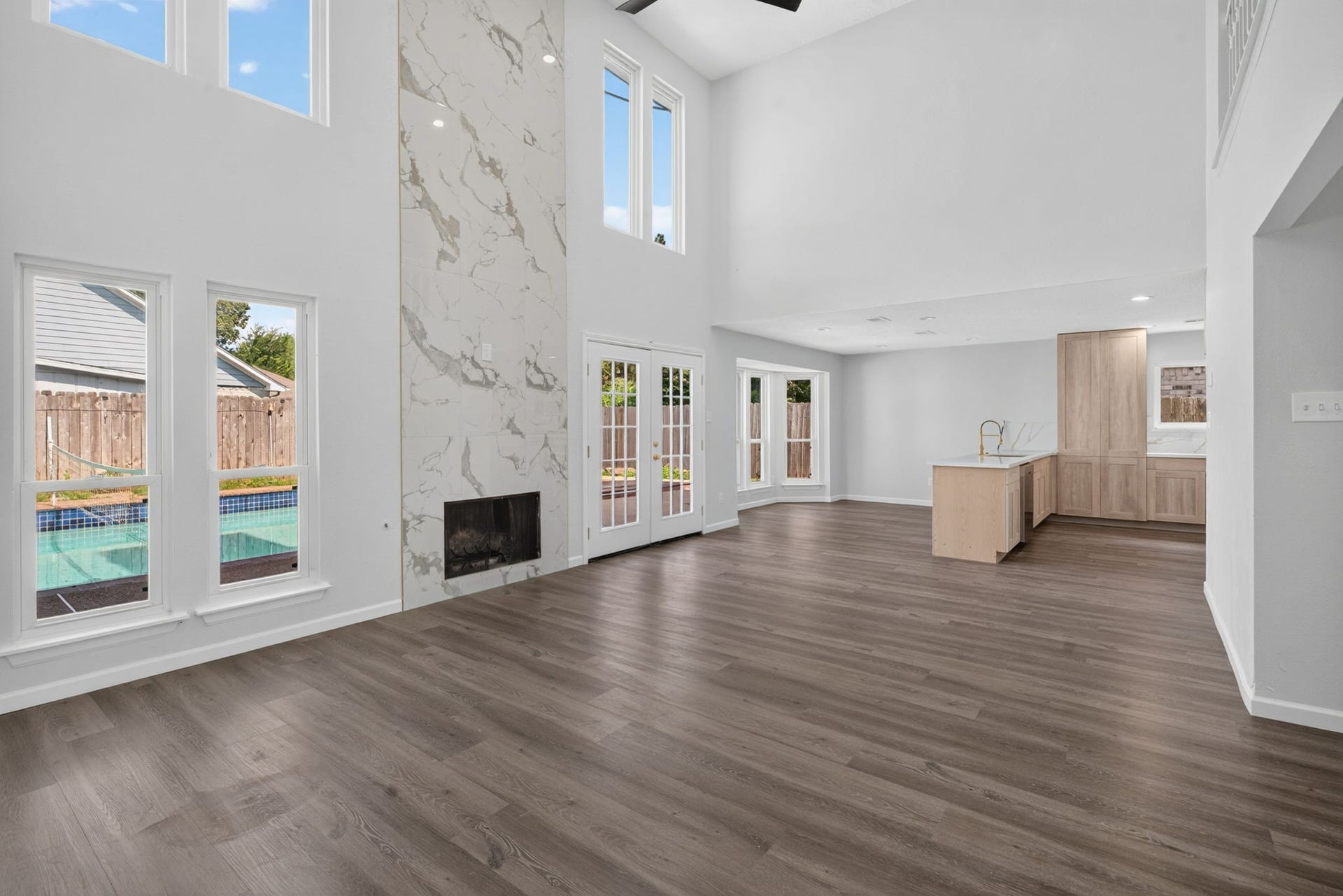 1123 Mayweather Lane, Richmond, TX 77406 An impressive two-story gathering space combines abundant natural light, a statement fireplace, and direct outdoor access for an airy indoor-outdoor lifestyle.