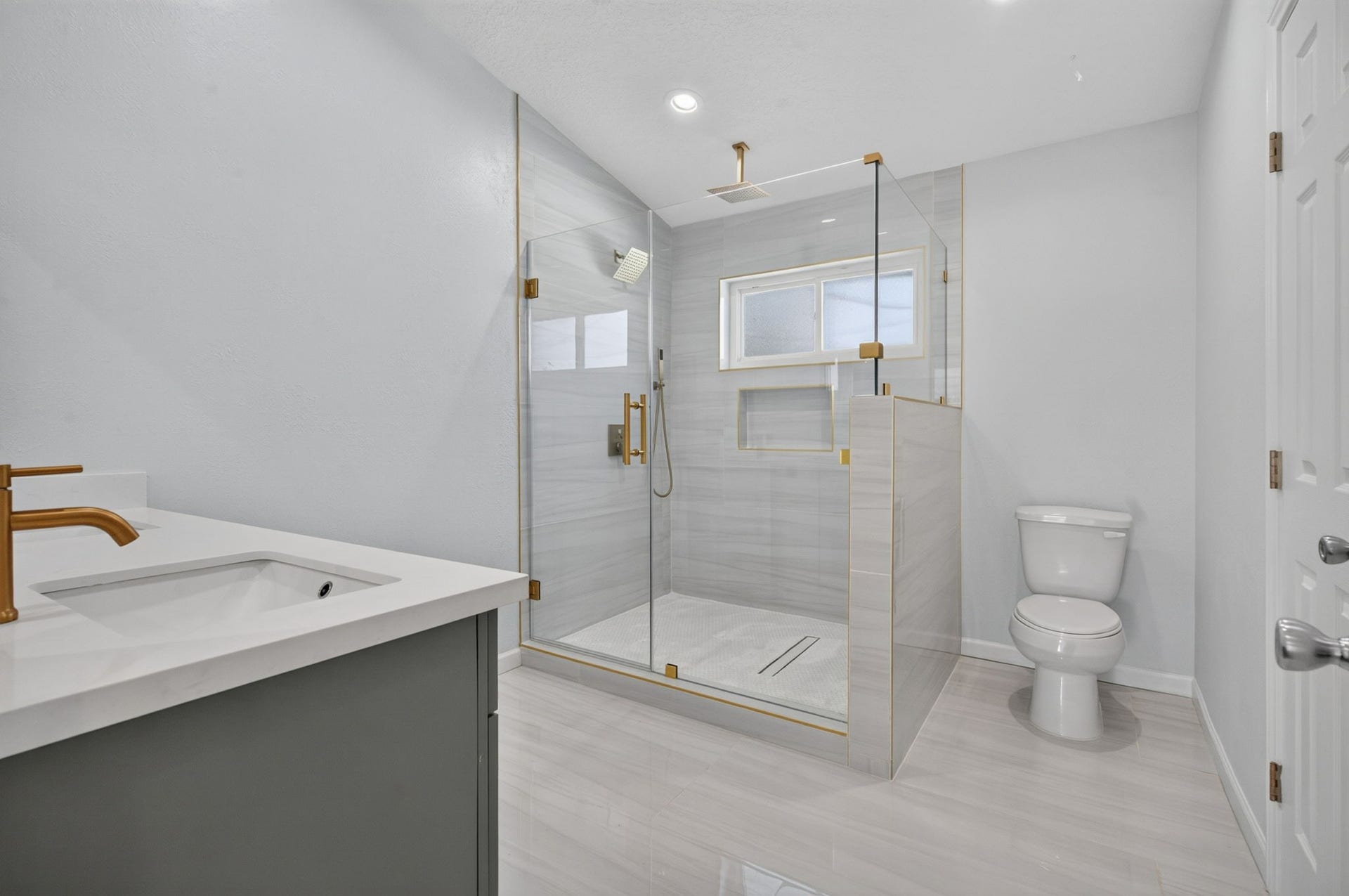 1123 Mayweather Lane, Richmond, TX 77406 Turn your morning routine into a spa experience with an oversized shower featuring sleek tilework, rainfall showerhead, and luxe gold fixtures.