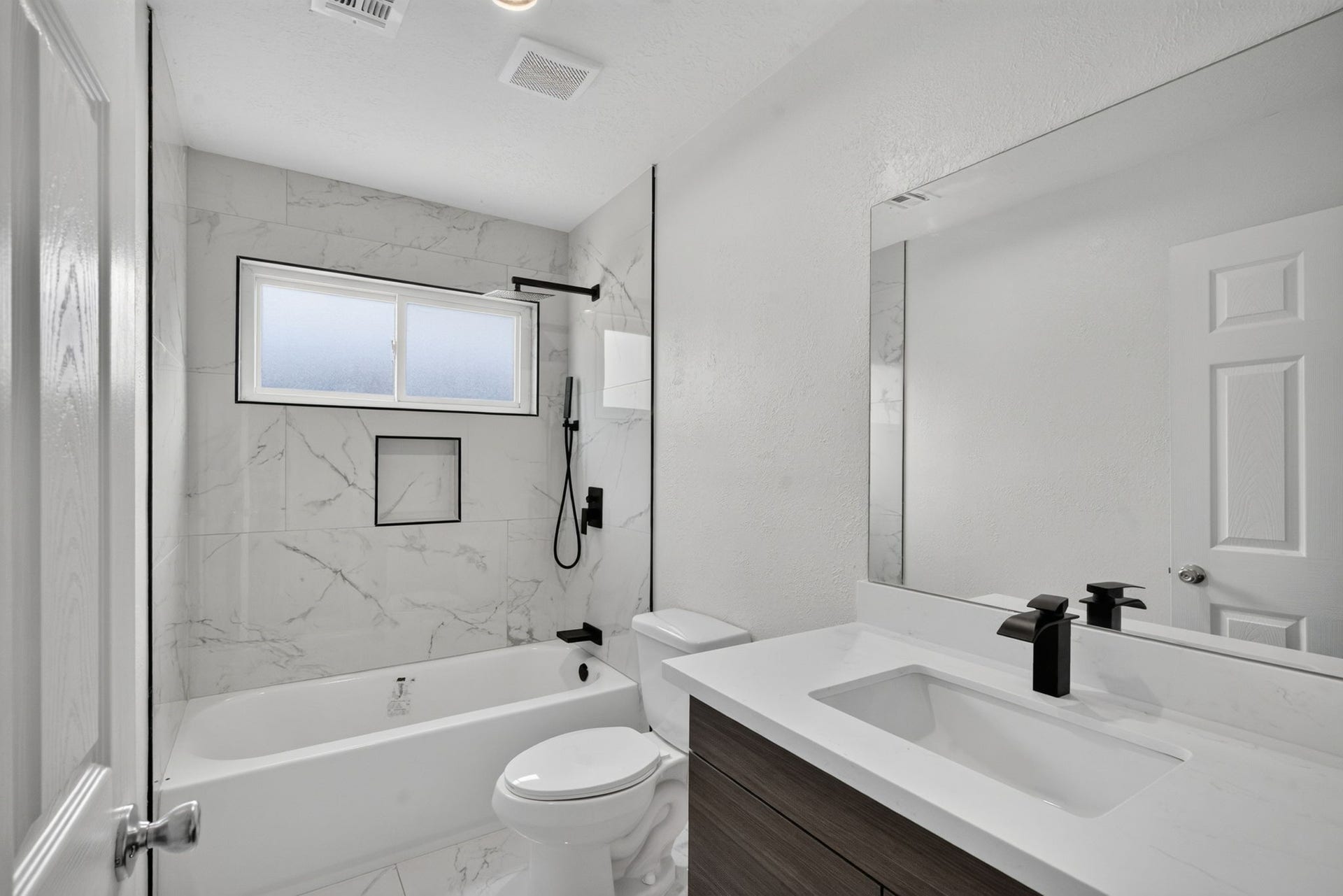 1123 Mayweather Lane, Richmond, TX 77406 Modern finishes elevate this beautifully updated bath, complete with sleek fixtures and a stylish tub-and-shower surround.
