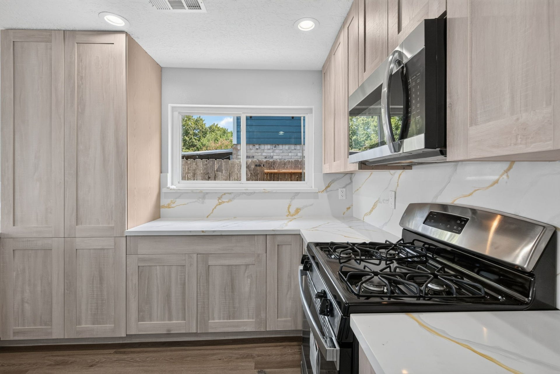 1123 Mayweather Lane, Richmond, TX 77406 Sleek stainless-steel appliances and striking gold-veined surfaces elevate the kitchen with just the right balance of modern style and warmth.