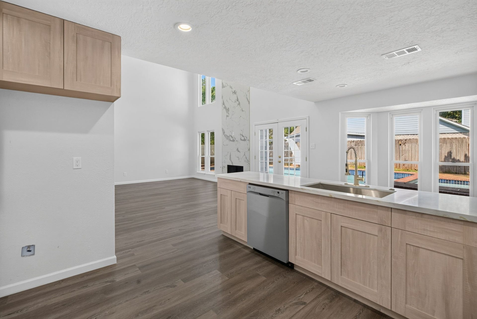 1123 Mayweather Lane, Richmond, TX 77406 An open layout makes hosting effortless, with the kitchen flowing naturally into the soaring great room and offering inviting views toward the pool.
