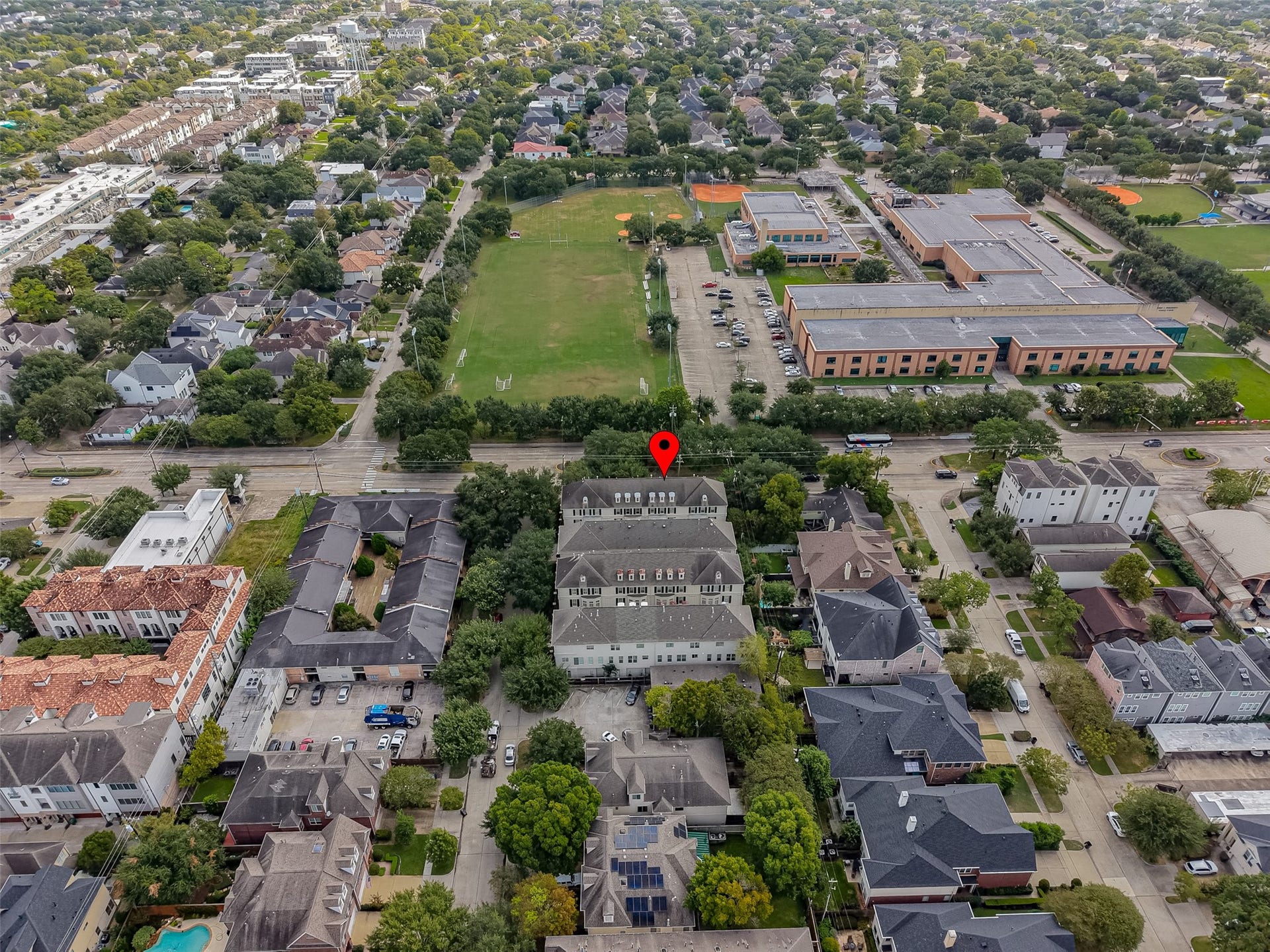 4003 Bellefontaine Street, Houston, TX 77025 Aerial perspective highlighting 4003 Bellefontaine within its gated townhome community, surrounded by mature trees and established residential streets. The location offers an inviting neighborhood setting with nearby green space and recreational fields.
