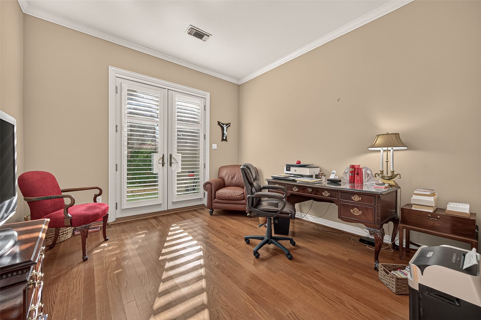 4003 Bellefontaine Street, Houston, TX 77025 Versatile first-floor room, ideal as a home office, featuring hardwood floors, crown molding, and abundant natural light. Double glass doors with plantation shutters open to the beautifully landscaped patio, creating an inviting indoor-outdoor connection.