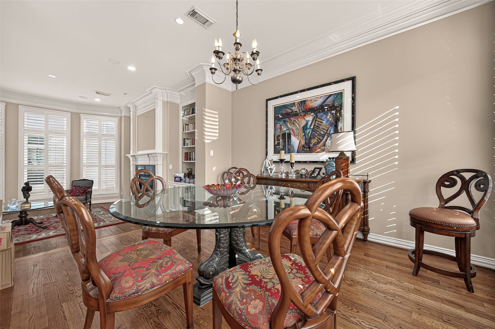 4003 Bellefontaine Street, Houston, TX 77025 Elegant dining area featuring hardwood floors, detailed crown molding, and a classic chandelier. An open connection to the living room creates an inviting setting for intimate dinners and entertaining.
