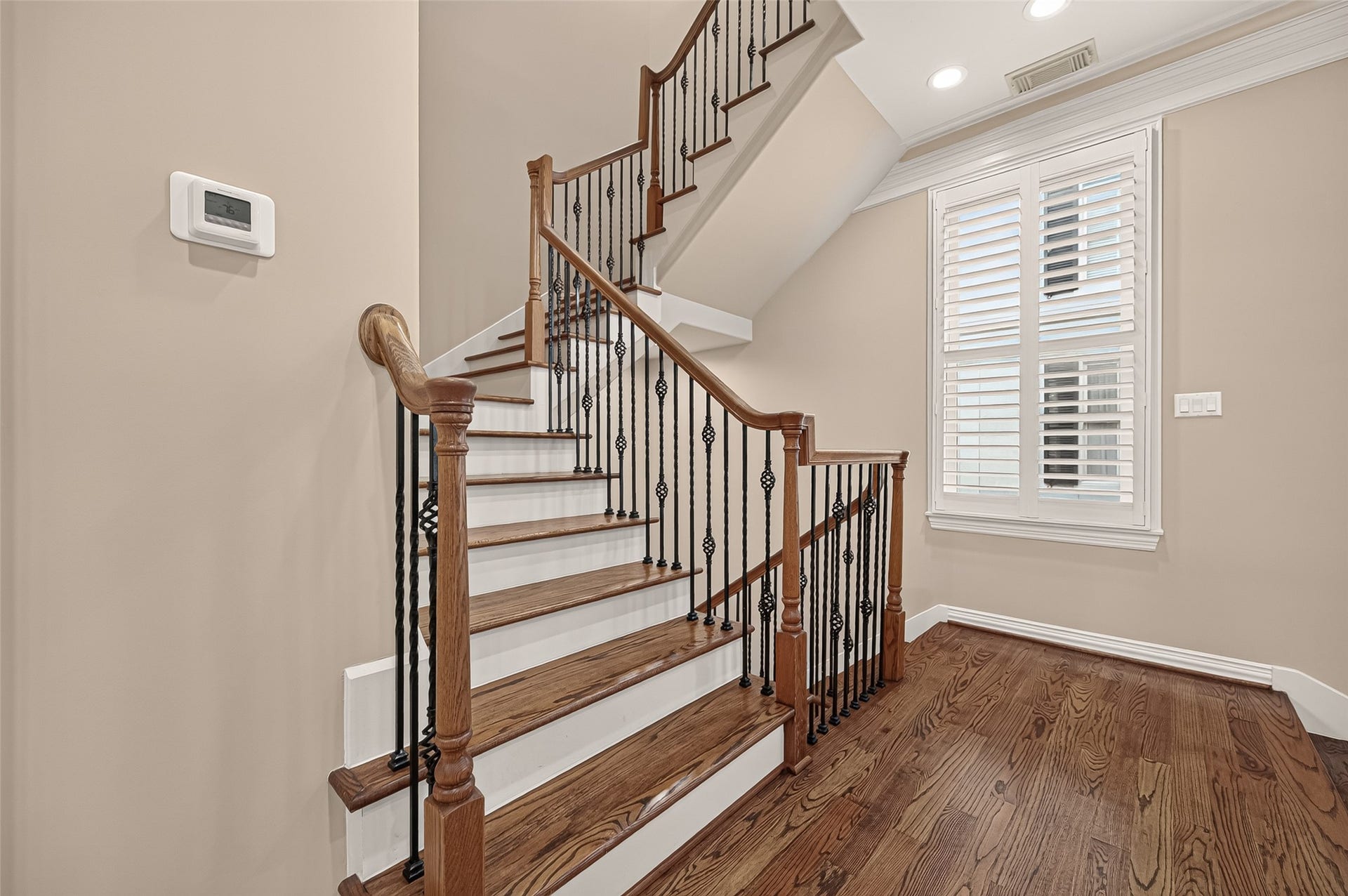 4003 Bellefontaine Street, Houston, TX 77025 Yes, second-floor landing is the correct term.
Light-filled second-floor landing featuring hardwood floors, decorative iron balusters, and plantation shutters, creating an elegant transition to the main living area.
