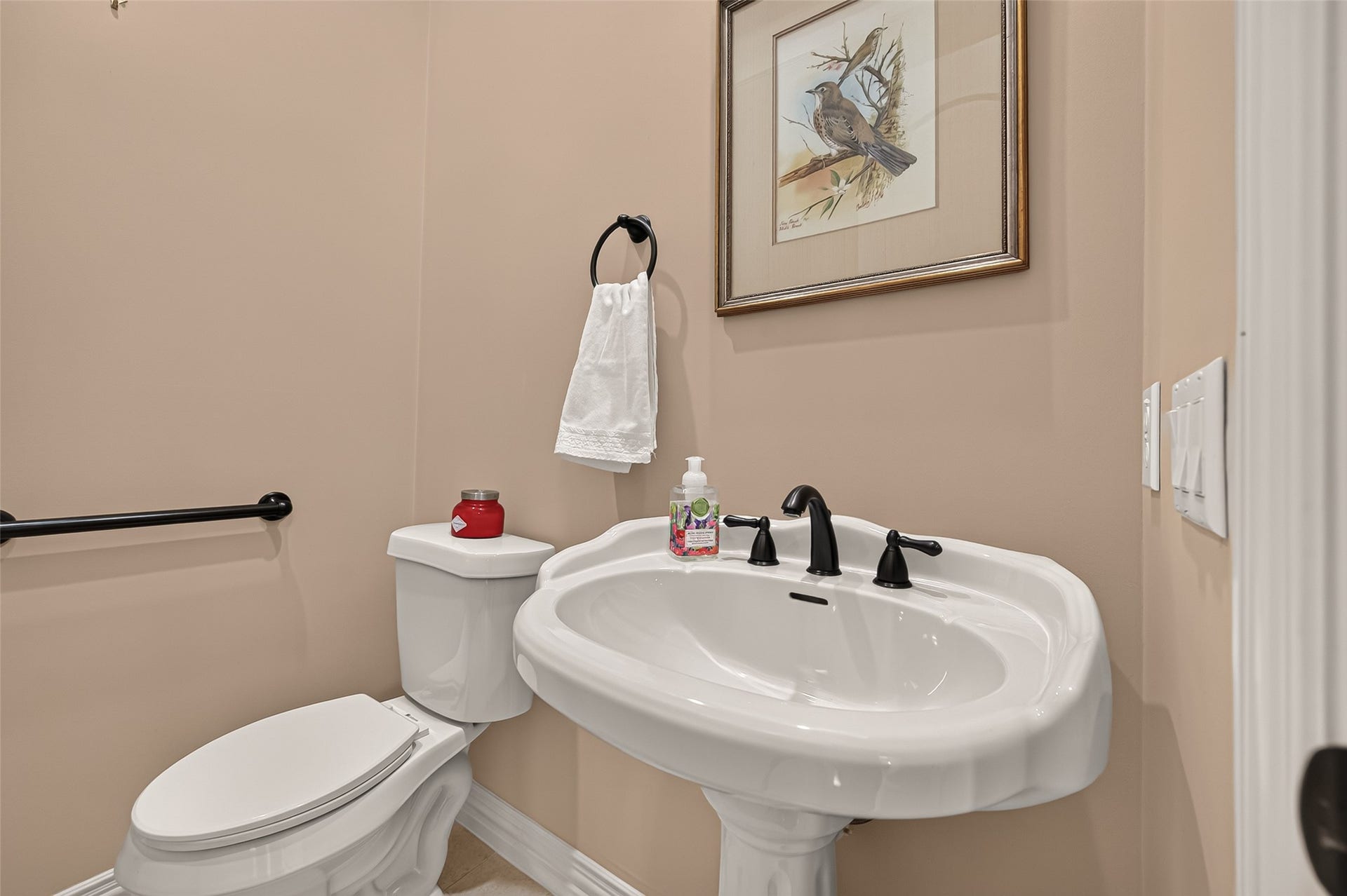 4003 Bellefontaine Street, Houston, TX 77025 Charming second-floor powder room featuring a classic pedestal sink, dark fixtures, and a warm neutral palette, conveniently located near the main living and entertaining areas.