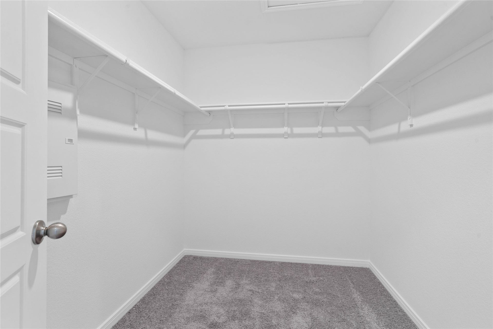 The primary walk-in closet features high shelving for seasonal storage while keeping your daily essentials within reach.