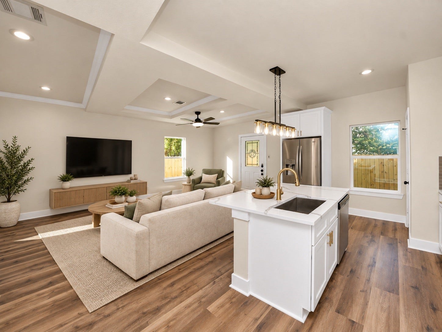 6671 Nielan Street, Houston, TX 77028 View from the kitchen showcasing the open-concept floor plan, oversized island, beautiful LVP flooring, decorative tray ceilings & abundant natural light | Virtually staged