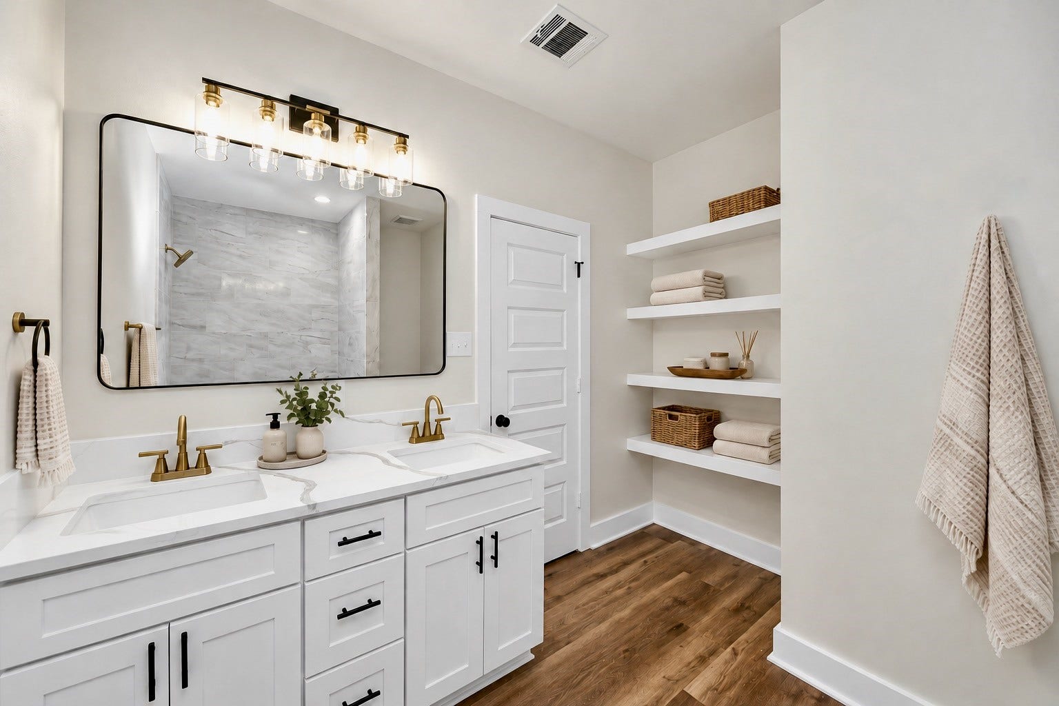 6671 Nielan Street, Houston, TX 77028 Primary bathroom featuring a double-sink vanity, quartz countertops, white cabinetry with modern hardware, stylish framed mirror, gold-tone fixtures & built-in shelving for additional storage.