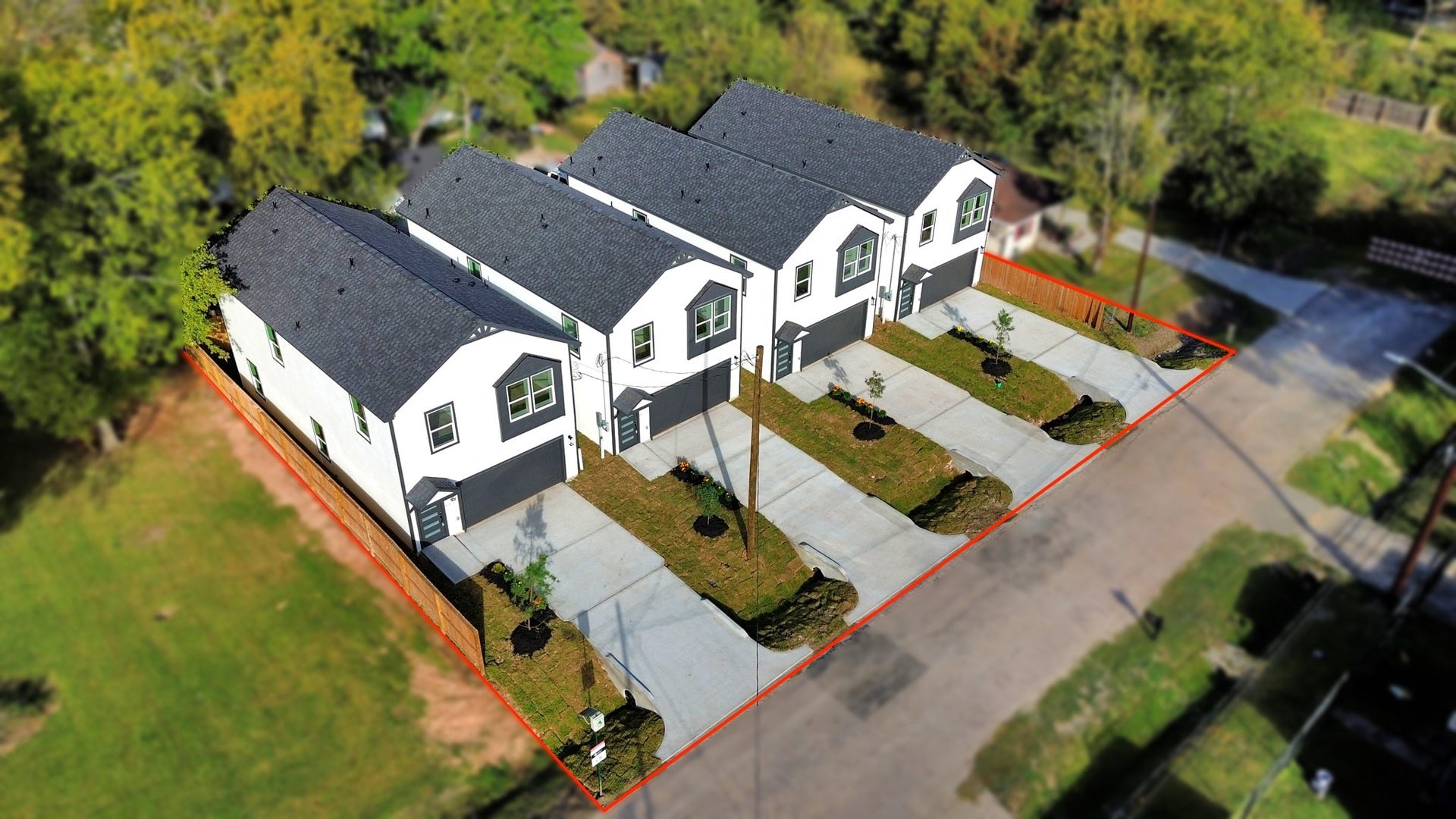 6671 Nielan Street, Houston, TX 77028 Elevated aerial perspective of all four newly completed Athelya Homes, showcasing their attractive modern exteriors, 2-car garages, private driveways & landscaped front yards.