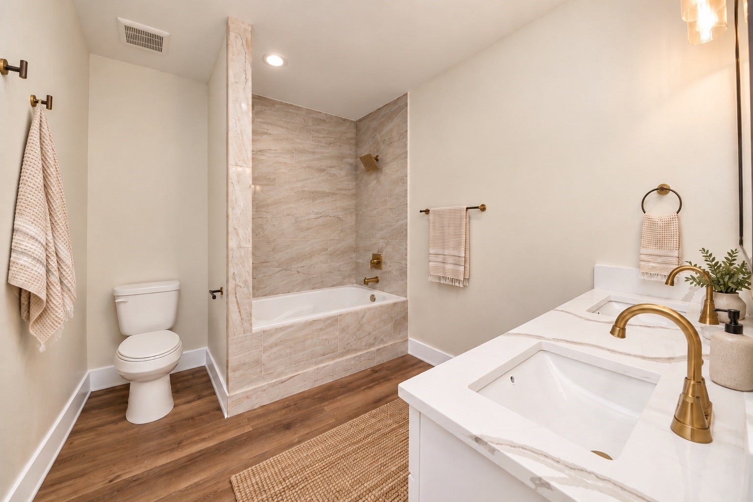 6671 Nielan Street, Houston, TX 77028 Private primary bathroom featuring a soaking tub with decorative tile surround, quartz vanity countertop, modern cabinetry, updated fixtures & attractive gold-tone hardware.