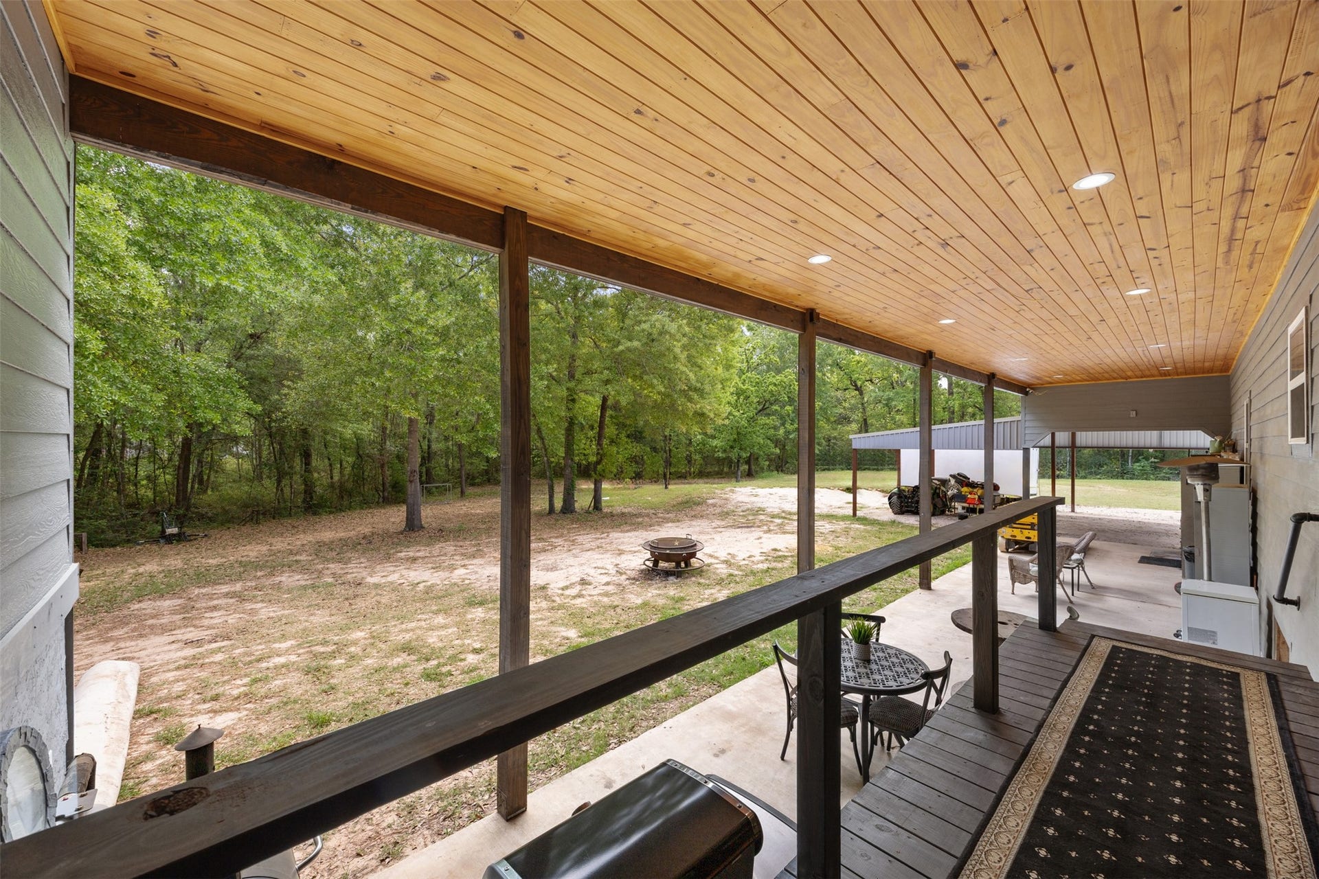 30902 Kate Drive, Magnolia, TX 77355 From the utility room exit, views of the back porch with outdoor entertaining and views of the wooded 2.5 acre lot
