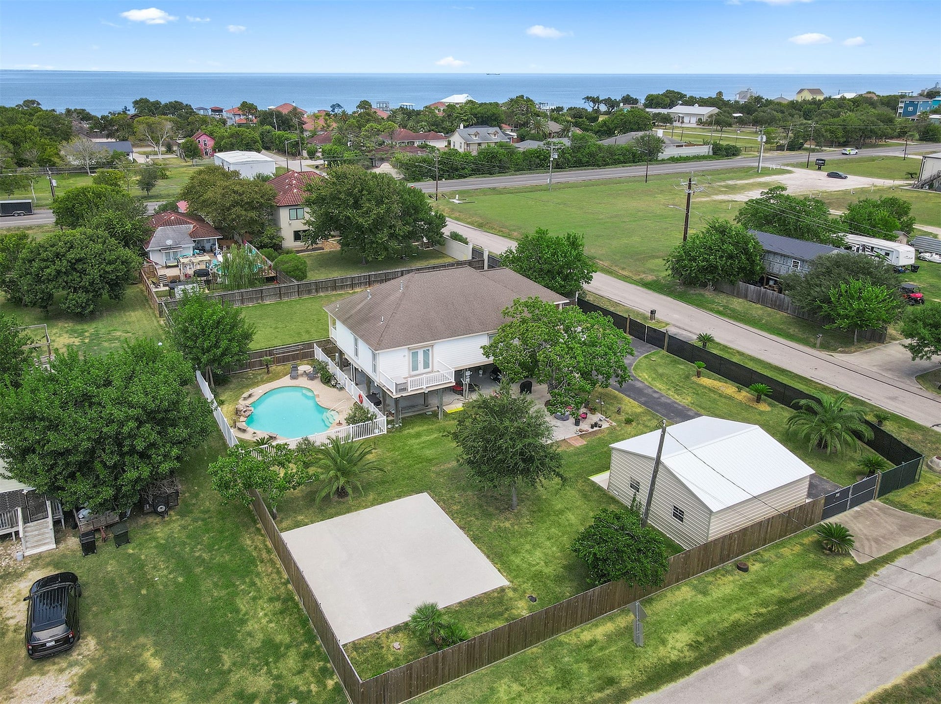 218 24th Street, San Leon, TX 77539 Spacious property with a charming home featuring a backyard pool, ample greenery, a detached garage/workshop, and additional pad, all close to Galveston Bay.