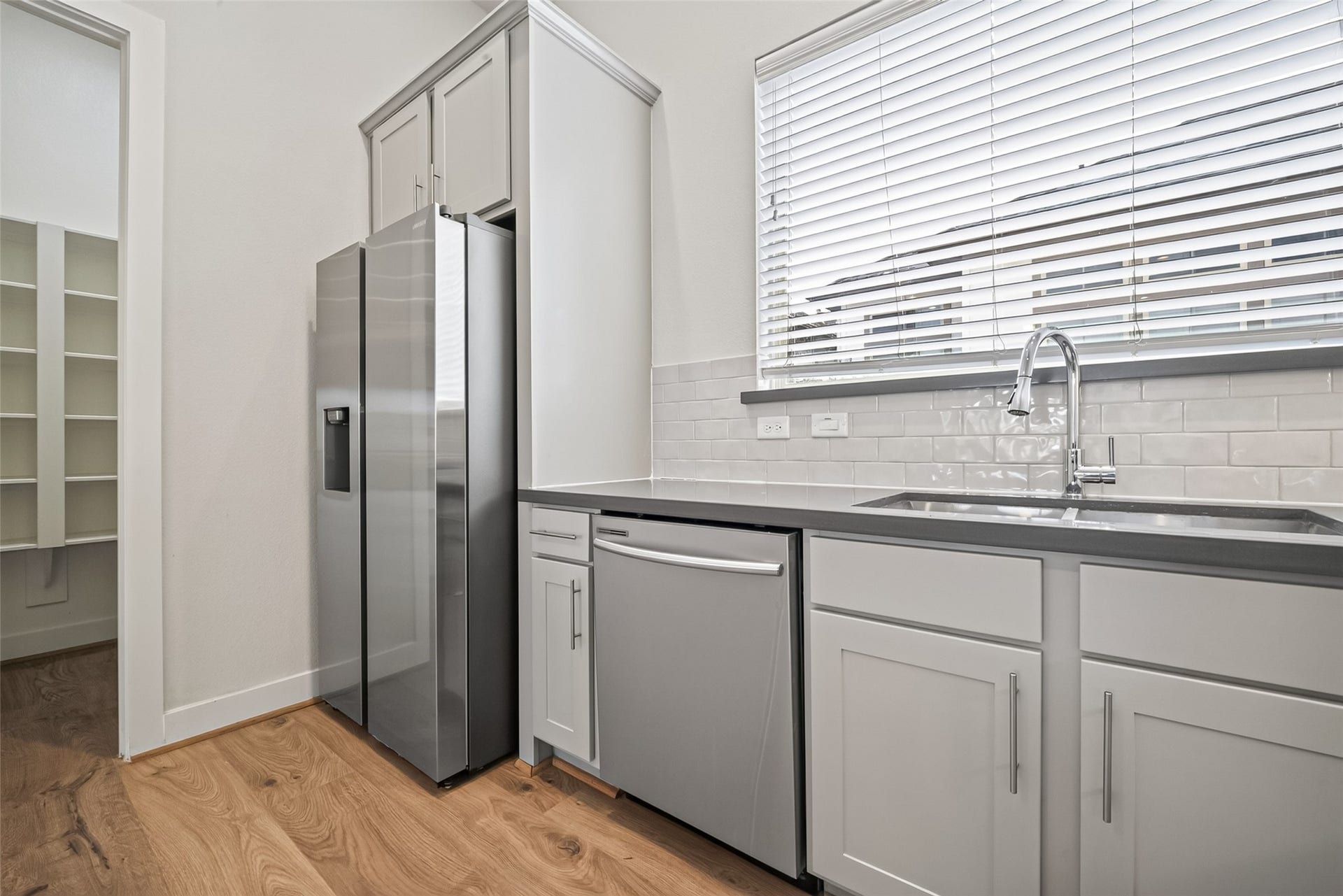 Modern kitchen with sleek stainless steel appliances, elegant countertops, and ample natural light from the large window.