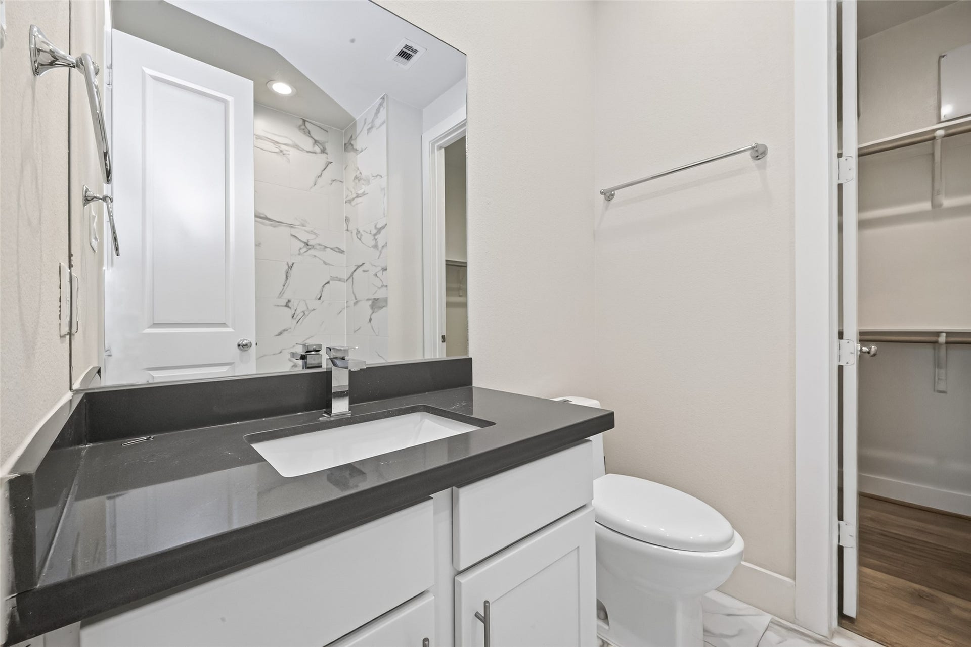 Sleek bathroom with a modern Taupe countertop, under-mount sink, and elegant marble-tiled shower.